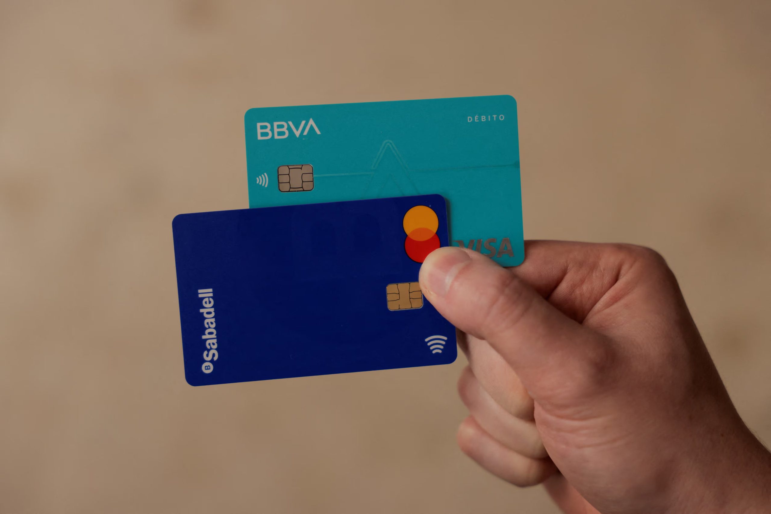 Un hombre muestra sus tarjetas de débito de los bancos BBVA y Sabadell, en Ronda, España, 9 de mayo de 2024. (Reuters /Jon Nazca)