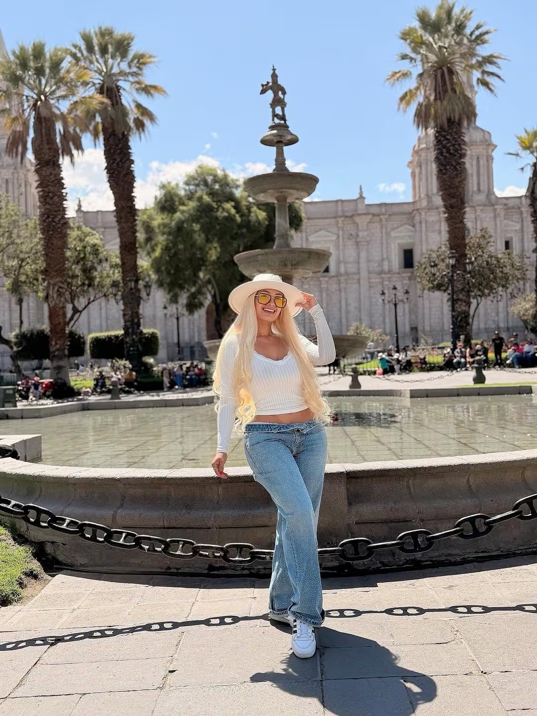 Nadeska Widausky, la modelo peruana buscada por Interpol, posa sonriente en una plaza pública antes de su reciente captura por las autoridades.
