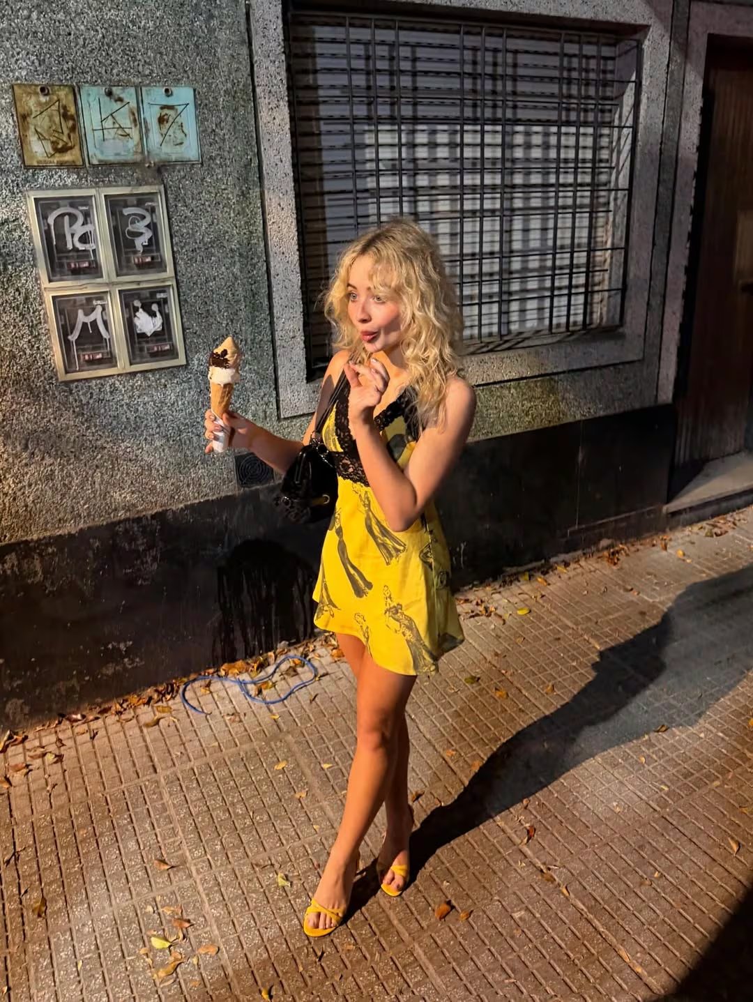 Vestido corto amarillo con estampado gráfico y sandalias intensas
