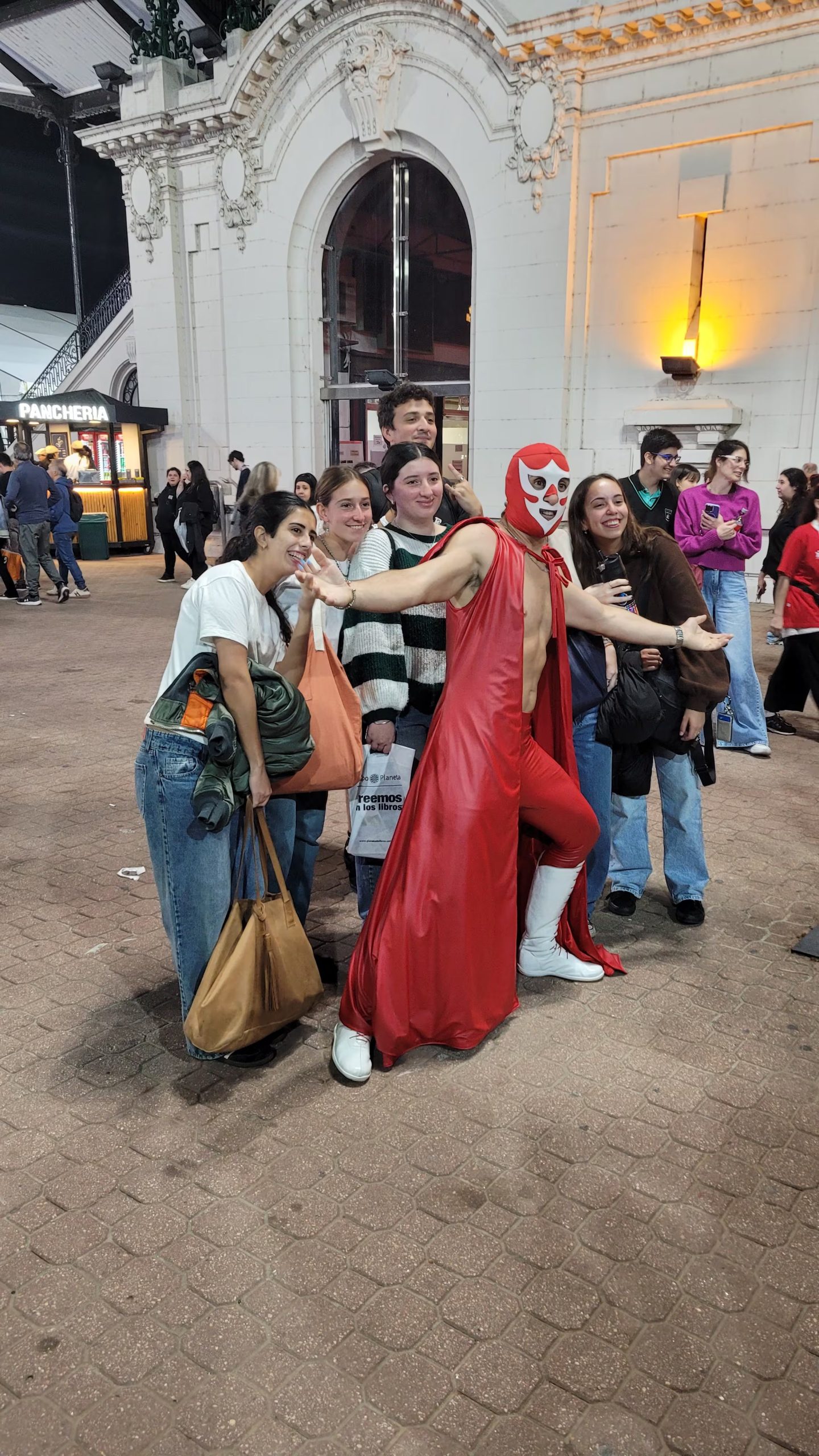 El Caballero Rojo posa con entusiastas visitantes en el marco de La Feria del Libro, captando la atención y generando alegría entre los asistentes.