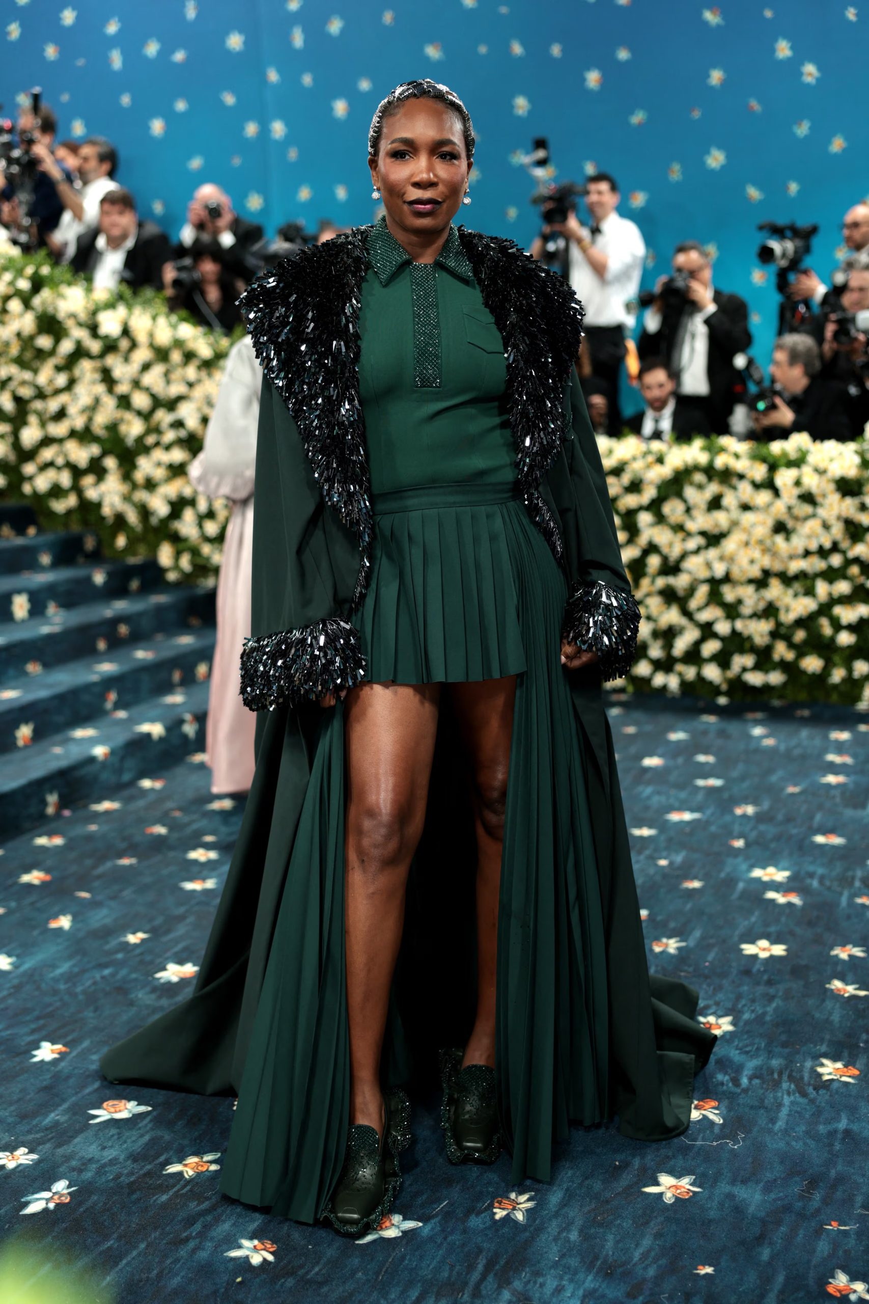 La apuesta por el color y la innovación se anticipa en el conjunto verde oscuro de Venus Williams, con falda tableada y abrigo largo, que promete sorprender en la alfombra roja (REUTERS/Mario Anzuoni)