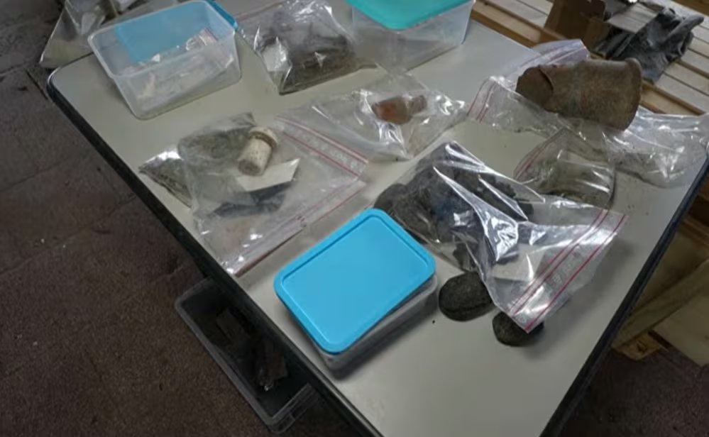 Un frasco de vidrio, botones y un peine, recuperados durante la obra del barracón, aportan indicios sobre la supervivencia bajo coerción (Captura de video)