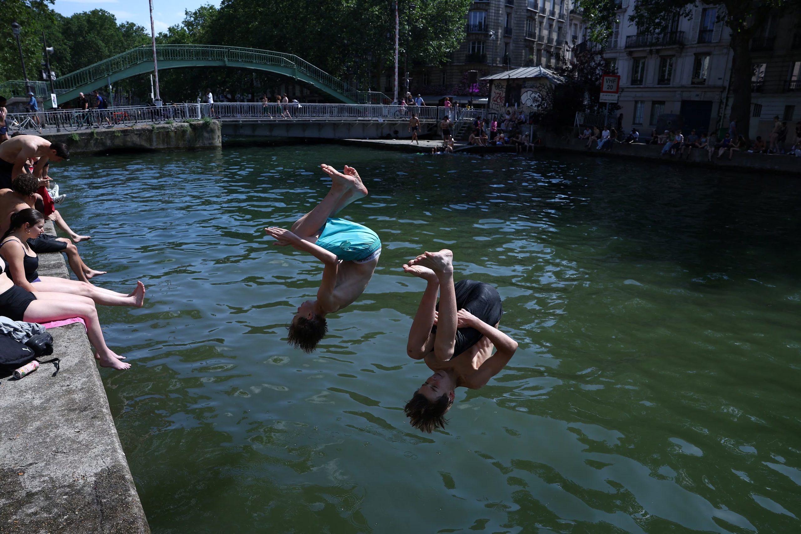 Unos niños se lanzan al Canal Saint-Martin, ya que se había permitido la natación pública en una parte del mismo debido al aumento de las temperaturas, en París, mientras una ola de calor azota gran parte de Francia. REUTERS/Alice Sacco