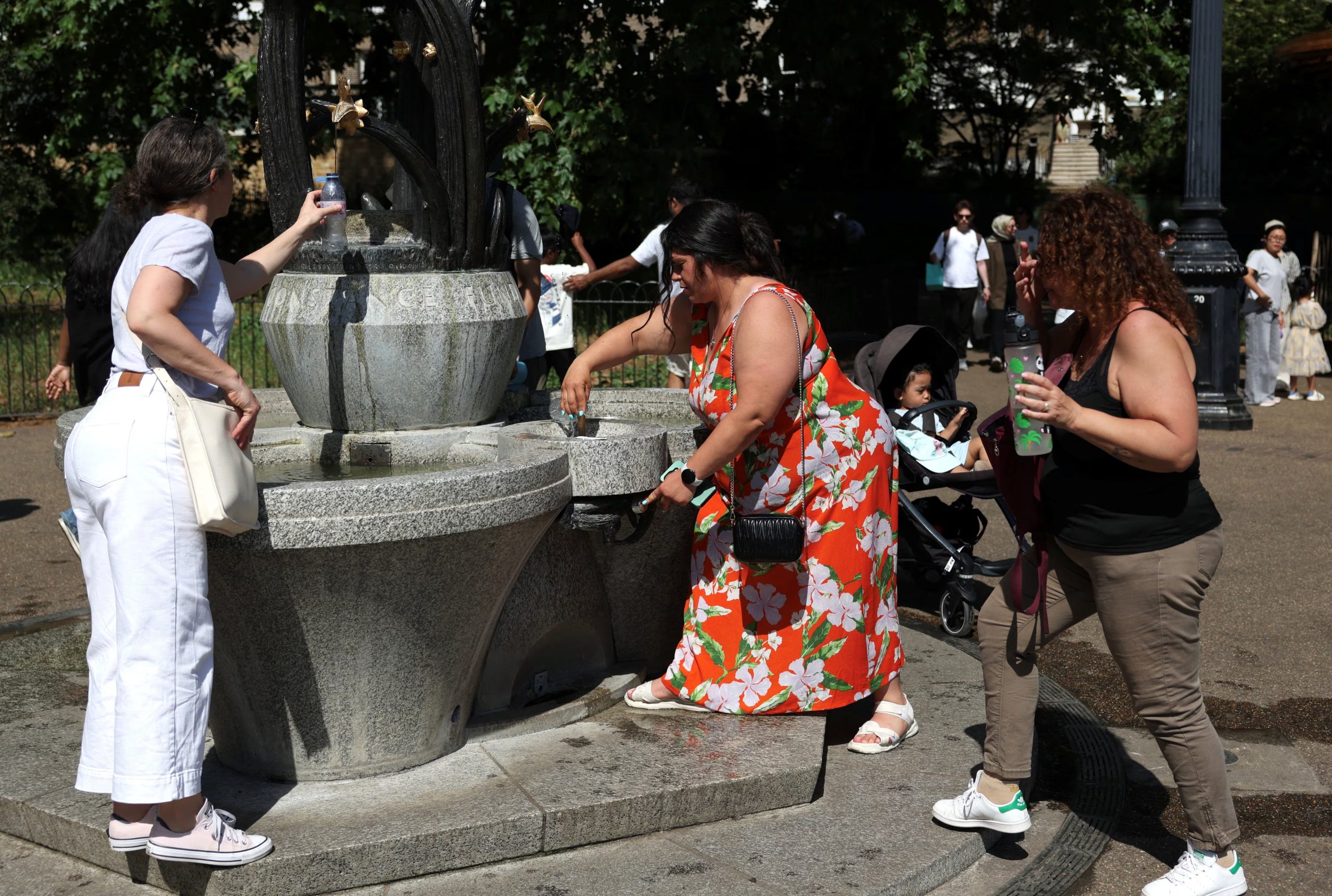 La gente rellena sus botellas de agua de una fuente en Green Park durante una ola de calor como el Reino Unido experimentó temperaturas récord para el mes de mayo en Londres, Gran Bretaña. REUTERS/Kevin Coombs