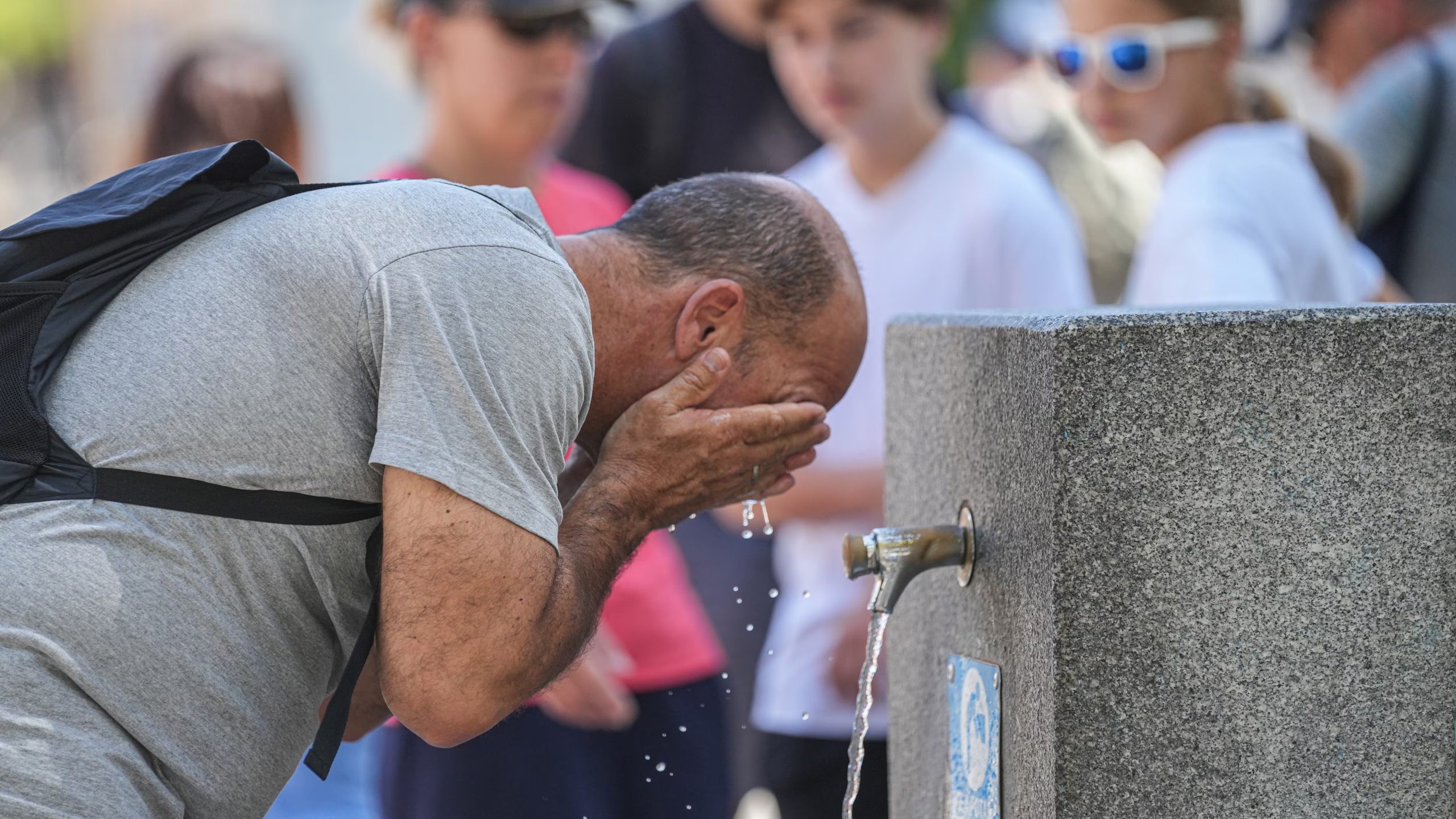 Un hombre se refresca en una fuente. (María José López / Europa Press)