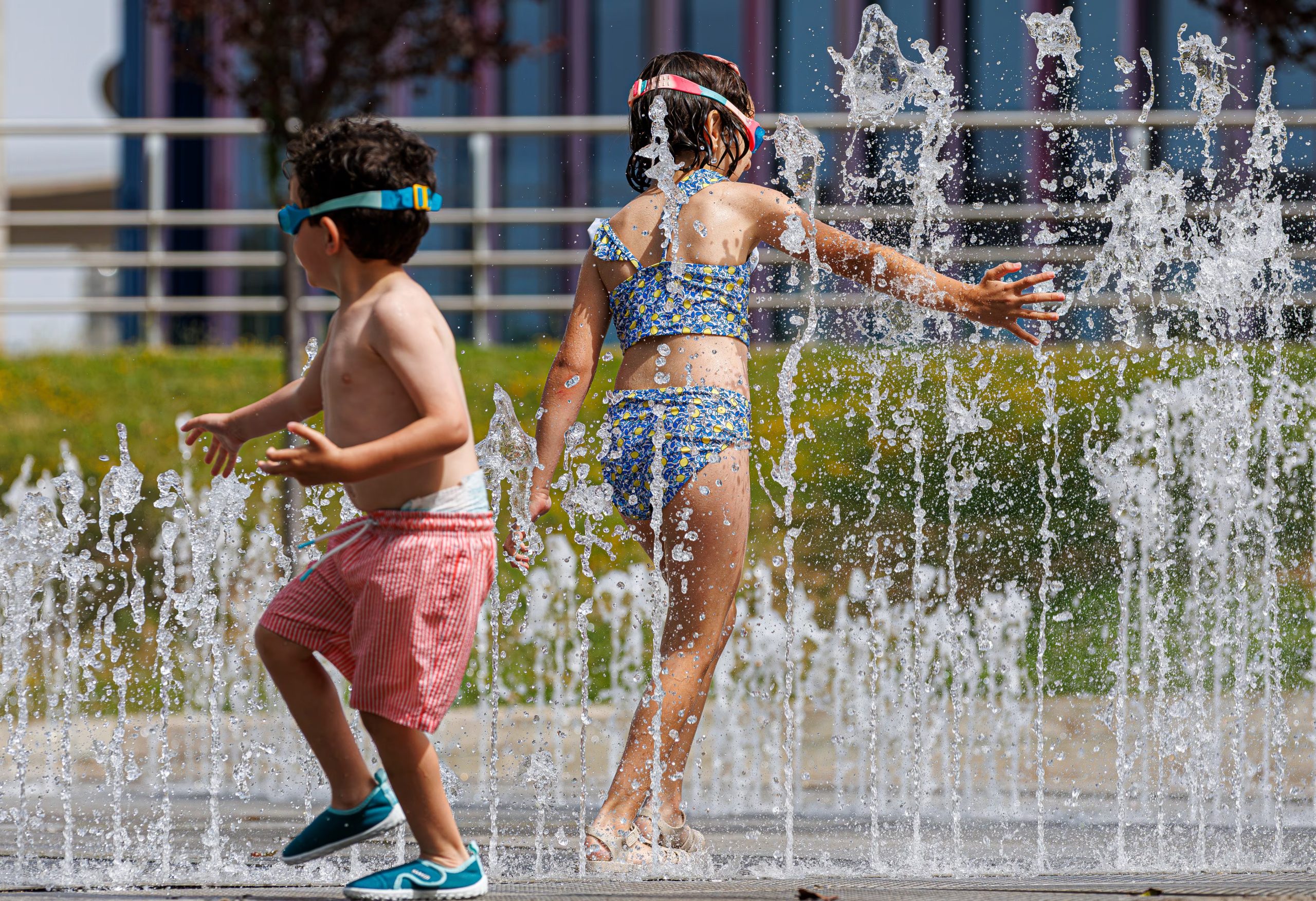 Varios niños disfrutan en unas fuentes en Zaragoza. (EFE/ Javier Belver)