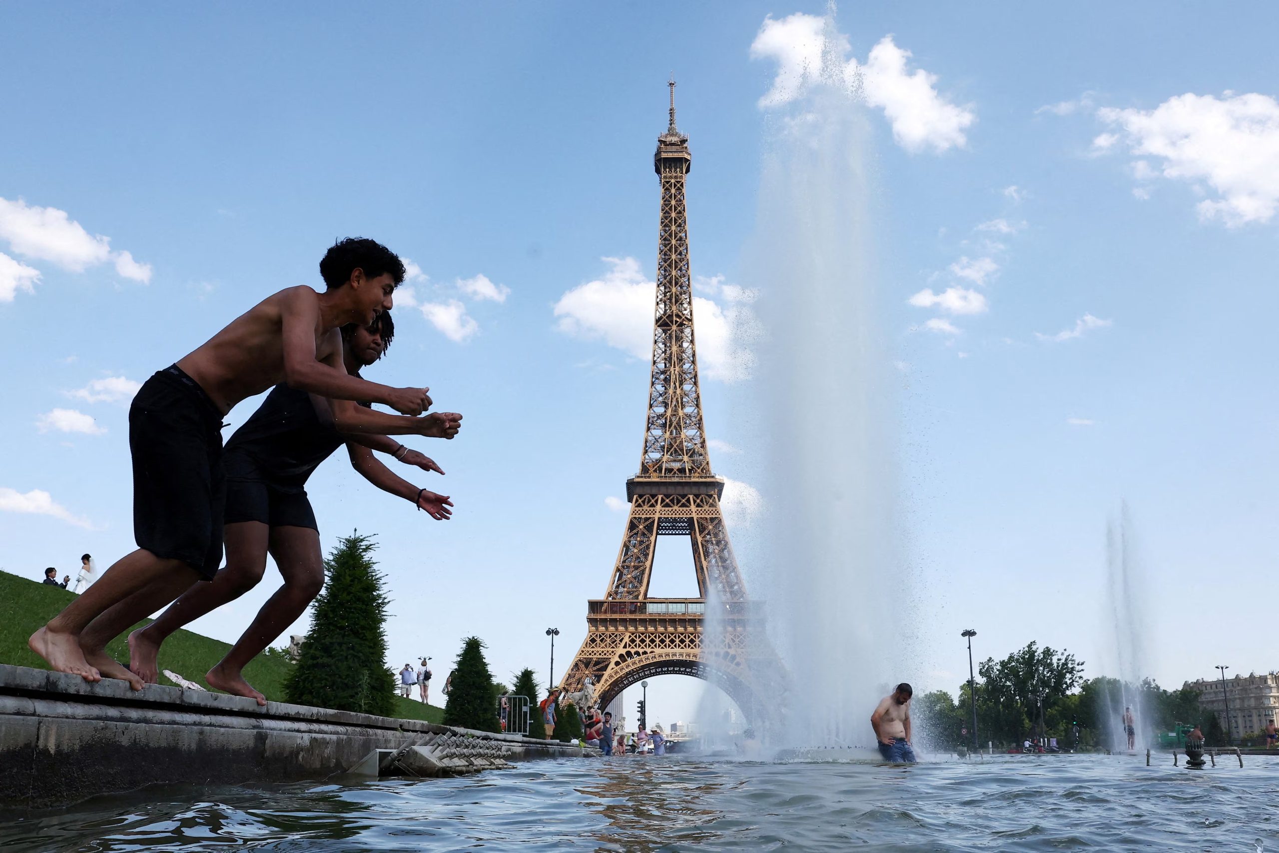 La gente se refresca en la fuente del Trocadero, junto a la Torre Eiffel de París, mientras suben las temperaturas durante una ola de calor que afecta a gran parte de Francia. REUTERS/Abdul Saboor