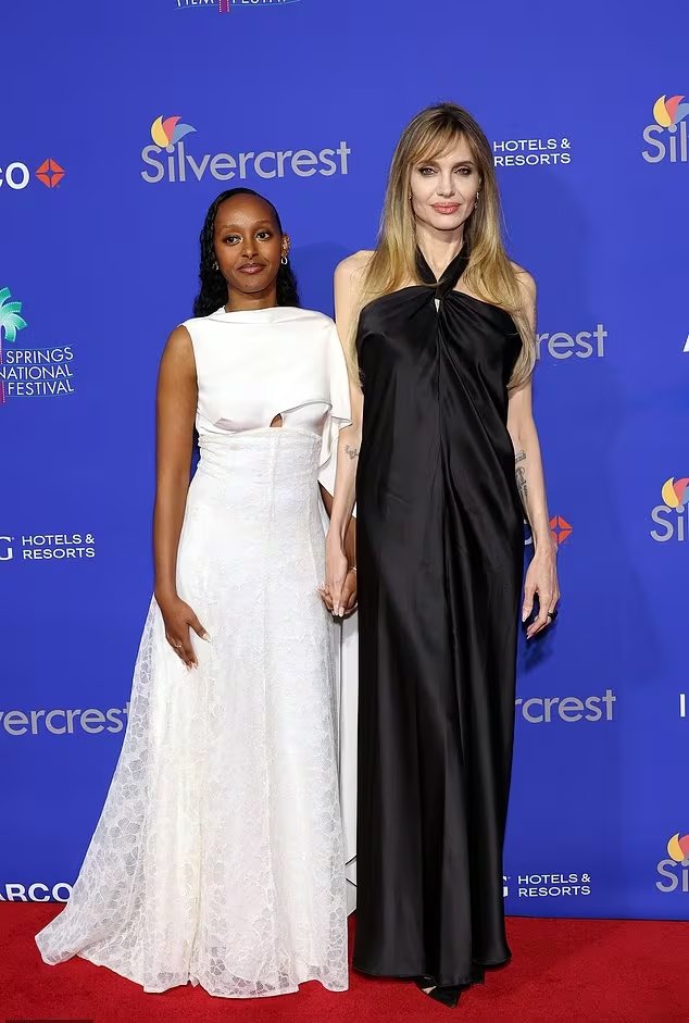 En el Palm Springs International Film Festival, Jolie elige un vestido negro satinado de escote halter y caída recta con maquillaje neutro (WireImage)