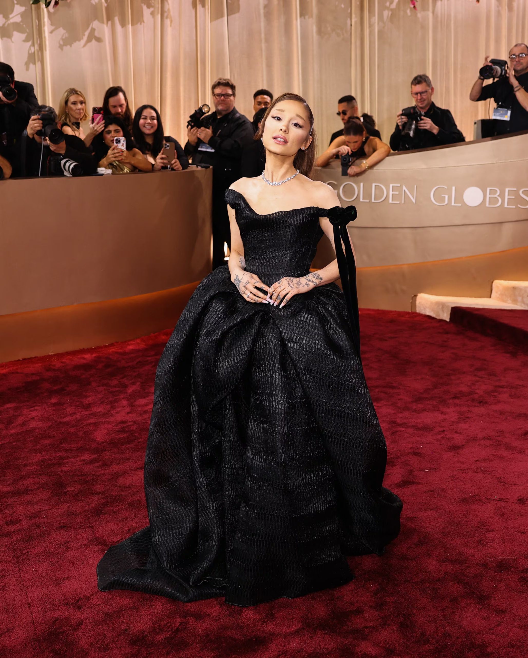 Vestido de gala negro con falda amplia y gran lazo, acompañado de diamantes y peinado clásico en la alfombra roja (REUTERS/Daniel Cole)
