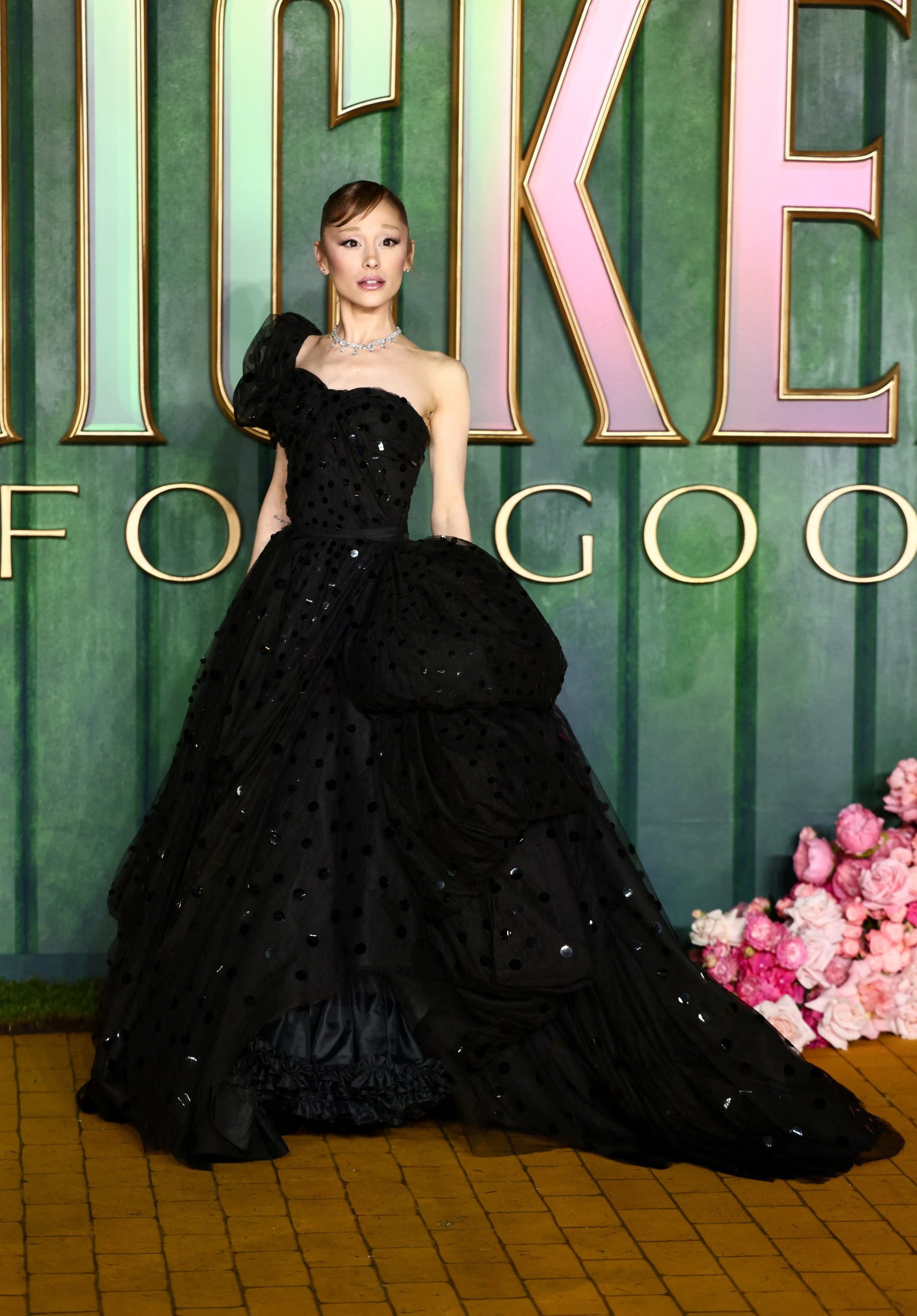 Vestido negro de un solo hombro con textura de lunares y gran volumen, resaltando la presencia en la alfombra (REUTERS/Jack Taylor)
