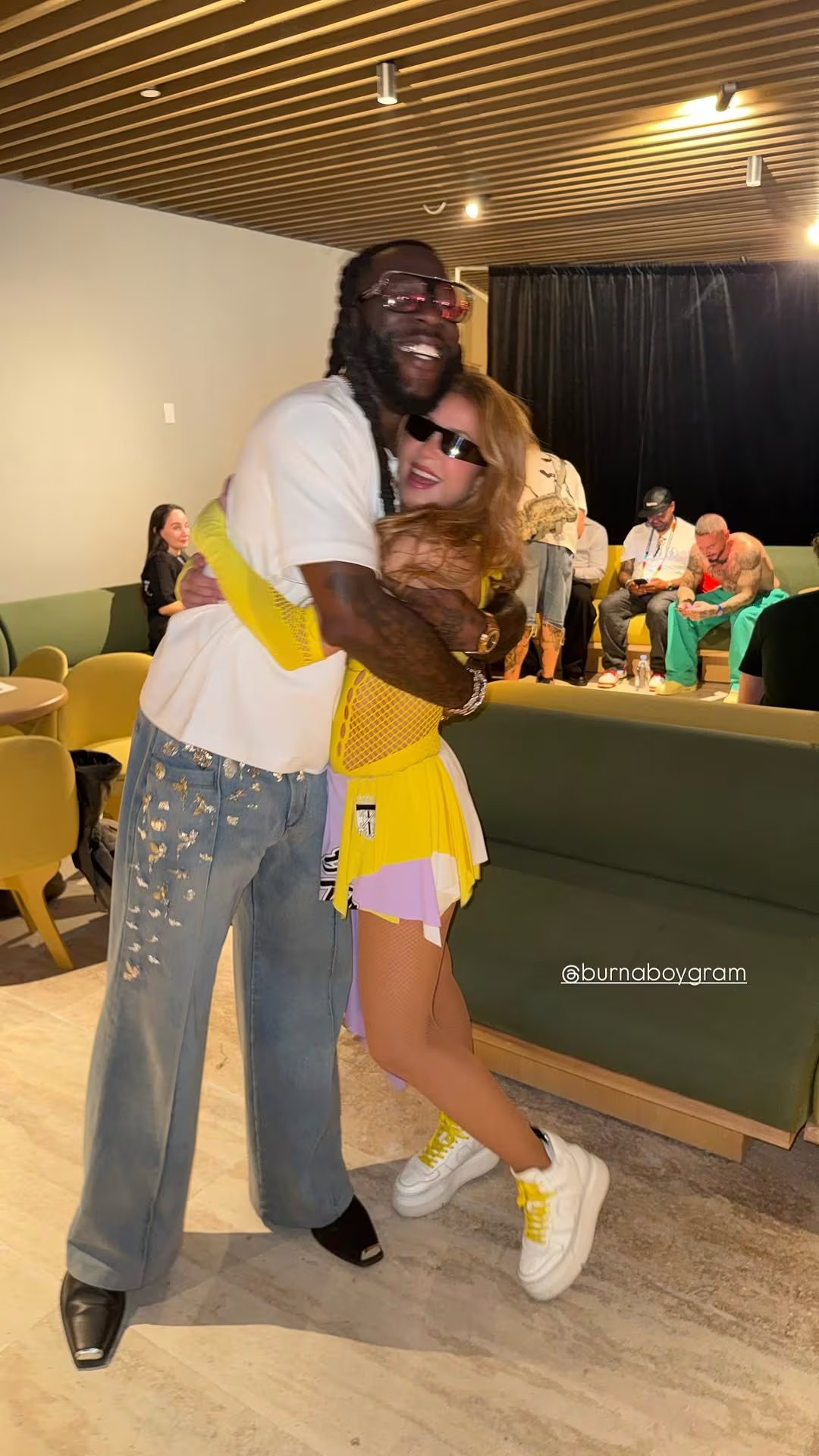 La superestrella colombiana Shakira y el cantante nigeriano Burna Boy se encuentran y se abrazan efusivamente en el Estadio Ciudad de México. (Instagram)