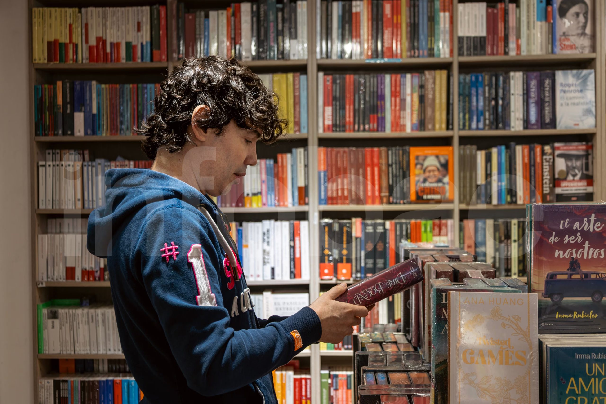 Bruno Pinasco, el reconocido presentador de televisión, explora las estanterías de una librería con atención, seleccionando un libro para leer. (Paula Elizalde)