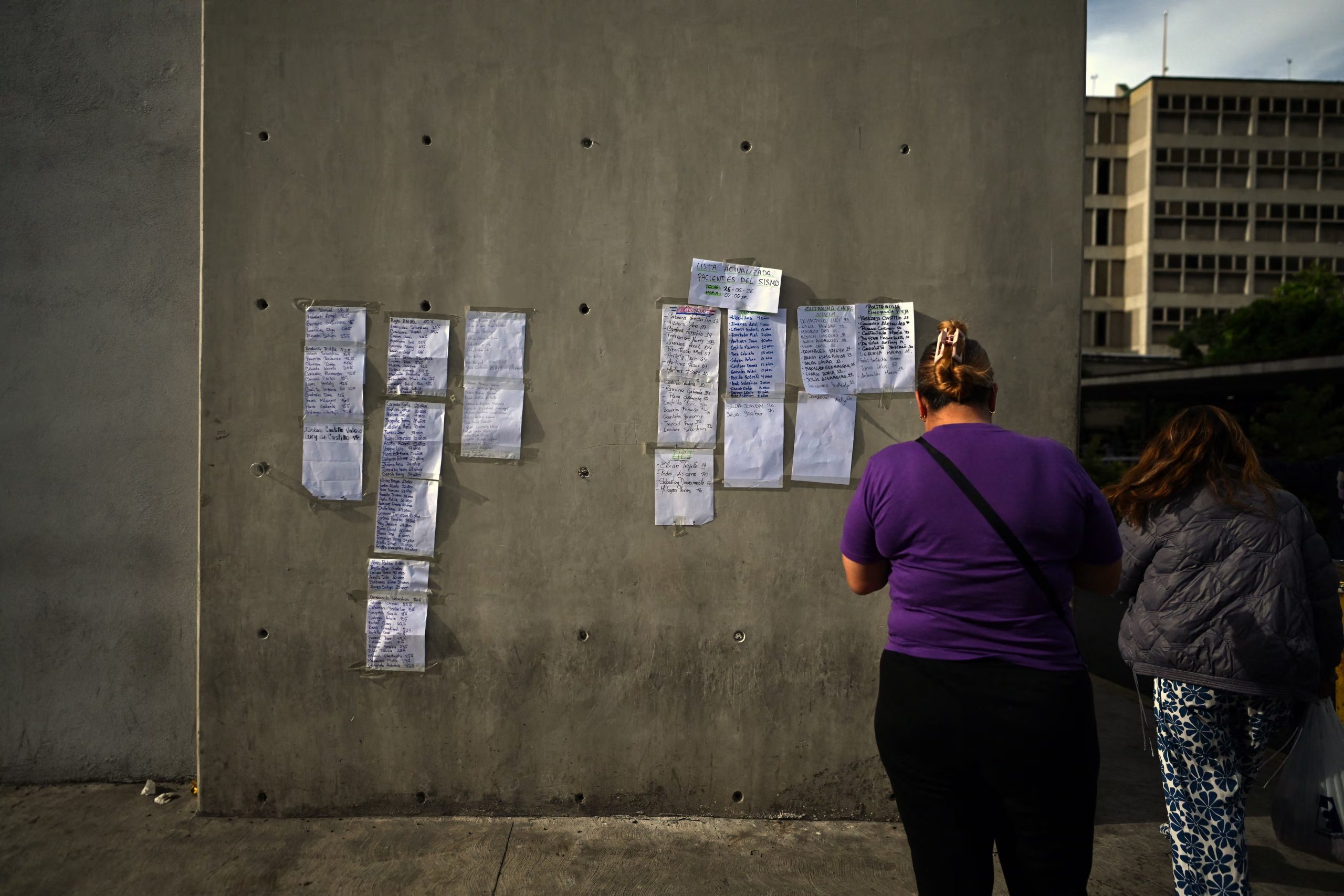 People search for the name of victims of the twin earthquake admitted at the Domingo Luciani hospital, in Caracas, on June 25, 2026. The death toll from twin quakes, measured at magnitudes 7.2 and 7.5, has risen to at least 188, with more than 1,520 others injured, top lawmaker Jorge Rodriguez reported, while residents continue searching for missing relatives. (Photo by Juan BARRETO / AFP)