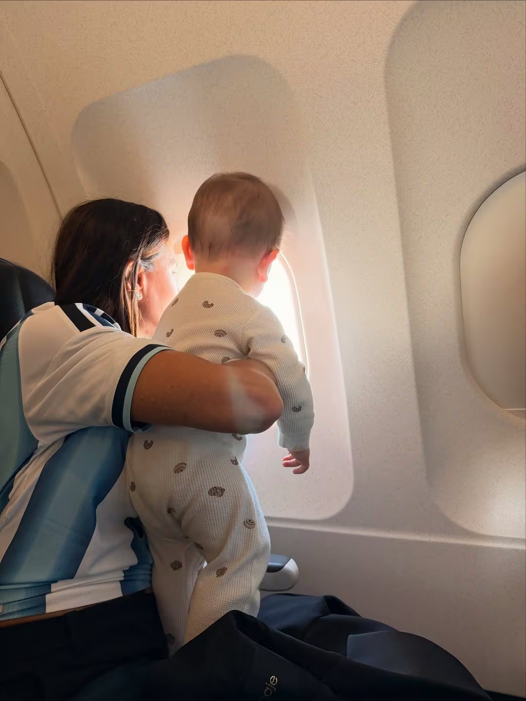 Bandini, junto a su nieto, observando por la ventanilla del avión mientras se dirigen al Mundial 2026