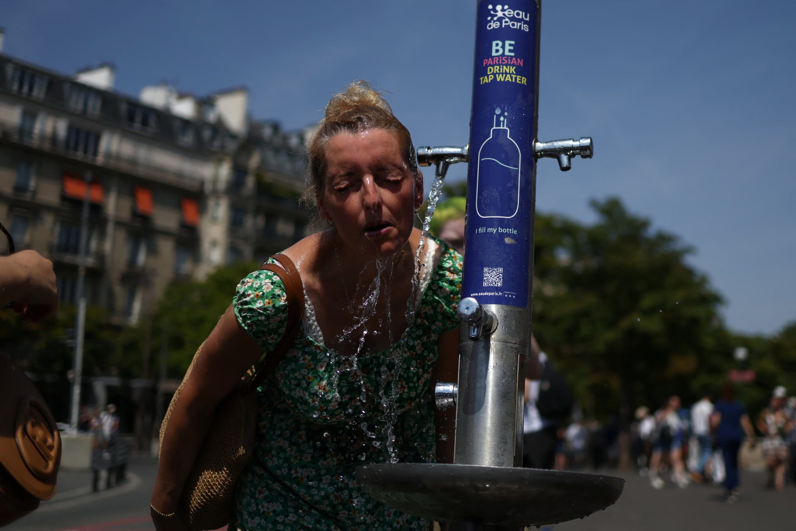 Una mujer se refresca en una fuente pública cerca de la Place du Trocadero durante una ola de calor en París (REUTERS/Tom Nicholson)