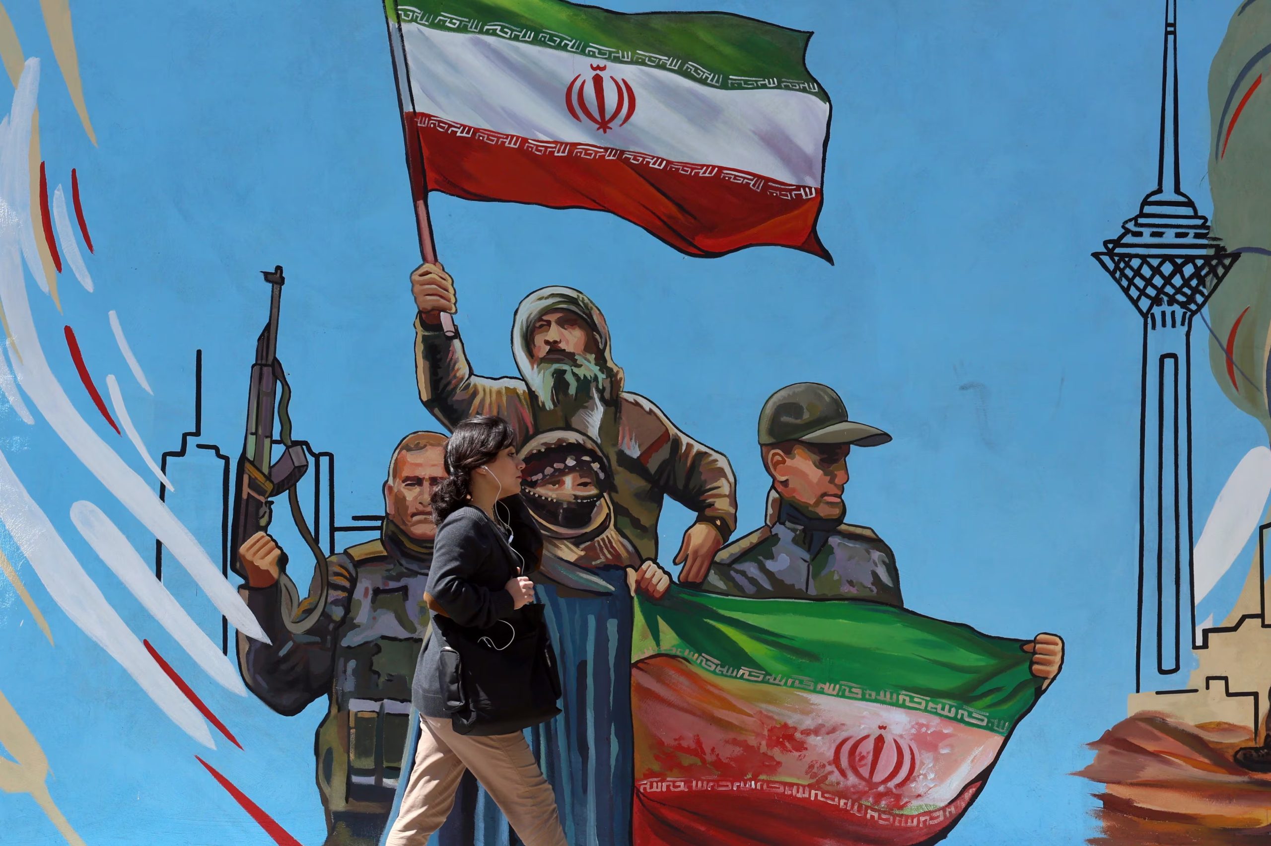 Una mujer pasa junto a un mural político en Teherán, Irán (EFE/EPA/ABEDIN TAHERKENAREH)