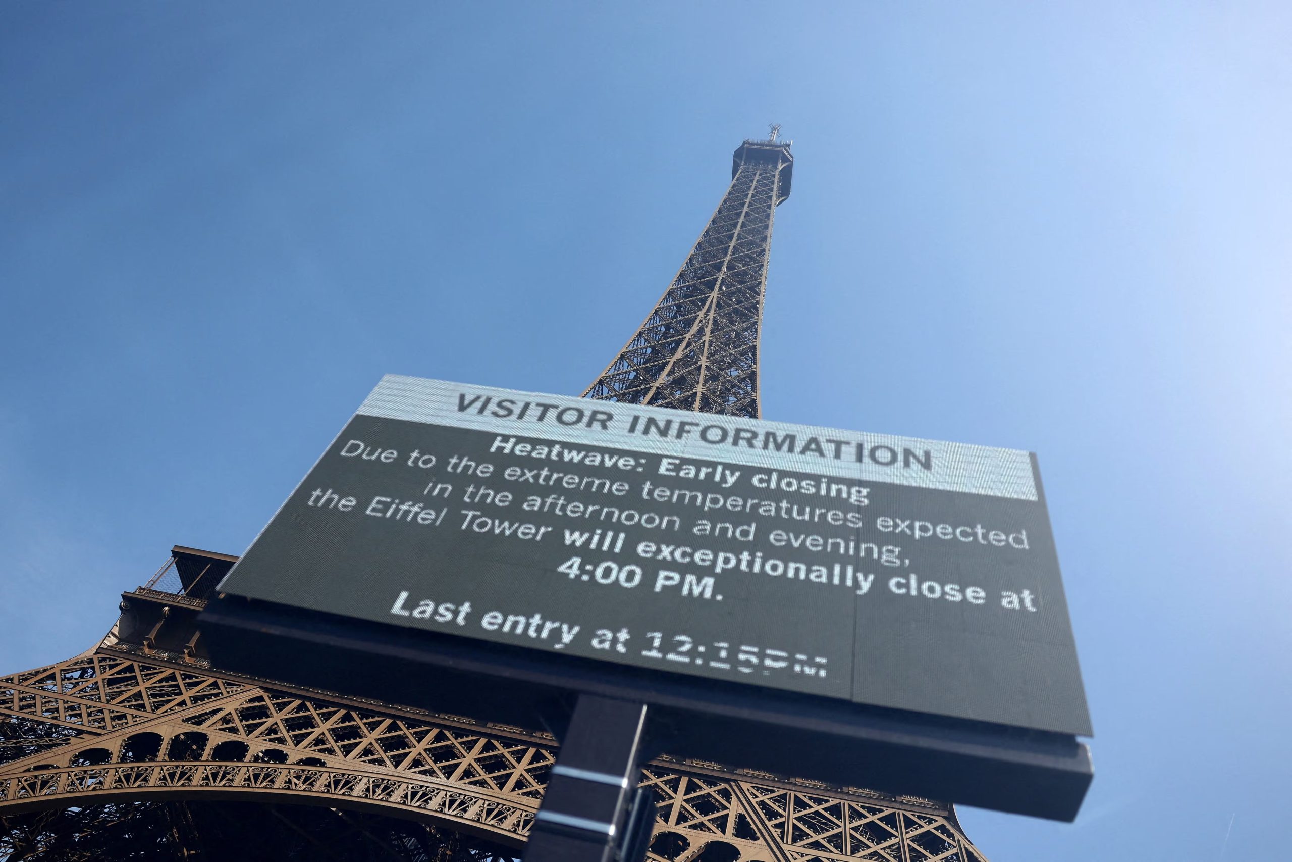 Un anuncio frente a la Torre Eiffel anuncia el cierra anticipado del monumento a las 16.00 horas por la ola de calor que sufre Francia. (Abdul Saboor/REUTERS)