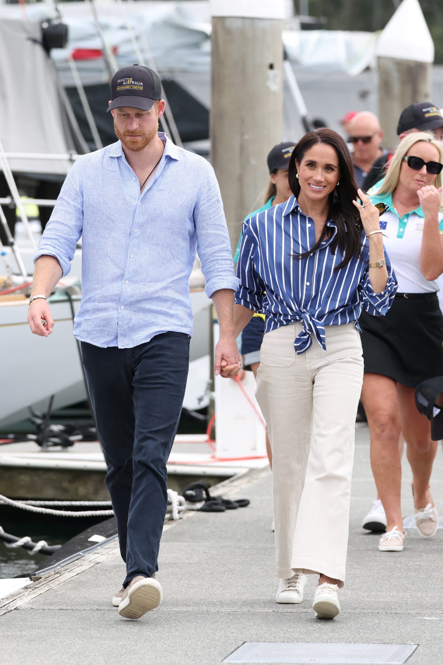 La camisa azul de rayas verticales se anuda en la cintura y se combina con pantalón blanco de tiro alto y zapatillas claras (REUTERS/Hollie Adams)