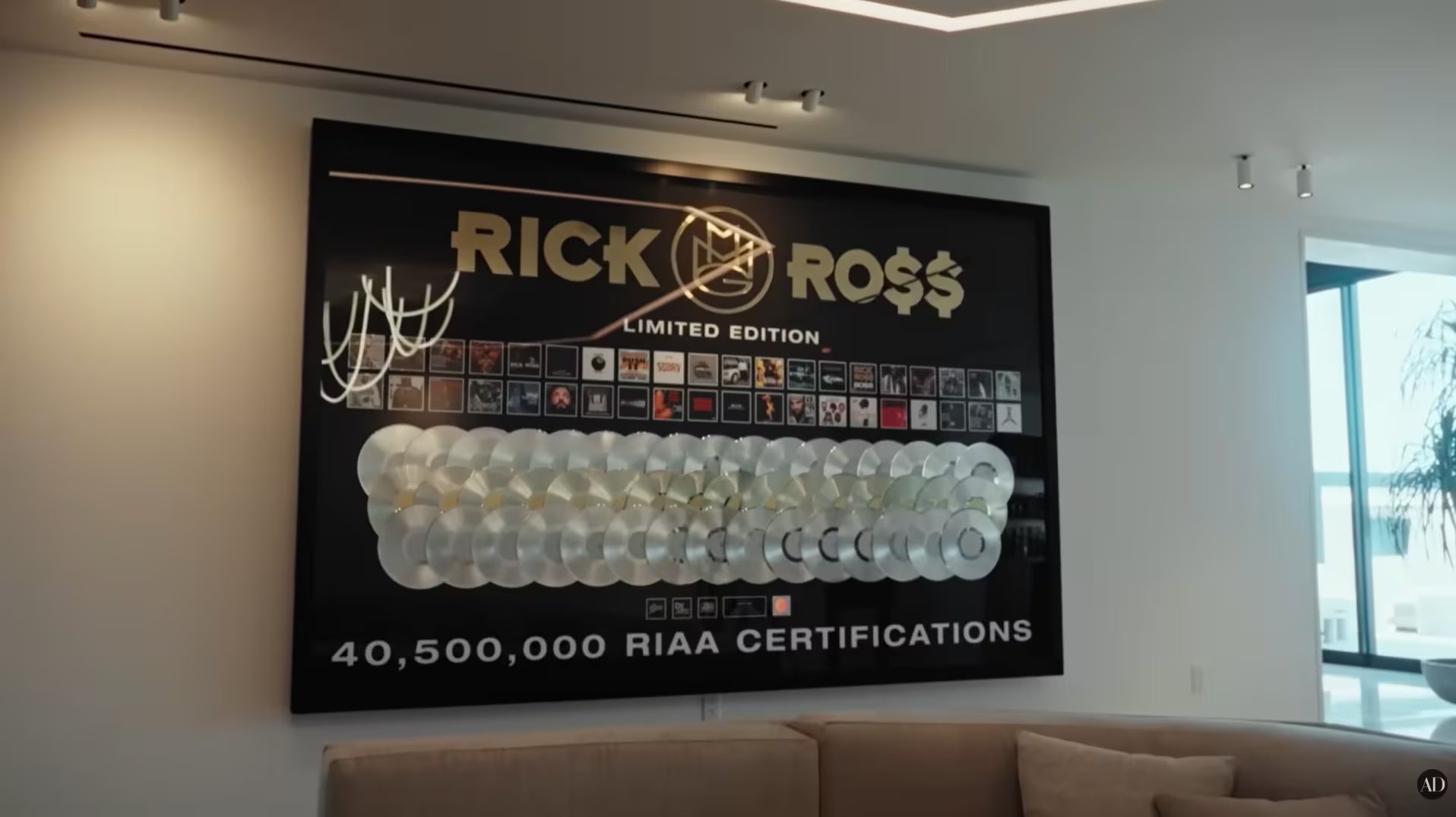 Los discos colgados funcionan como una galería personal de logros, integrada al diseño interior de la mansión y pensada para recordar el recorrido artístico de Rick Ross sin romper la estética de lujo del ambiente. (Video Youtube /Architectural Digest)