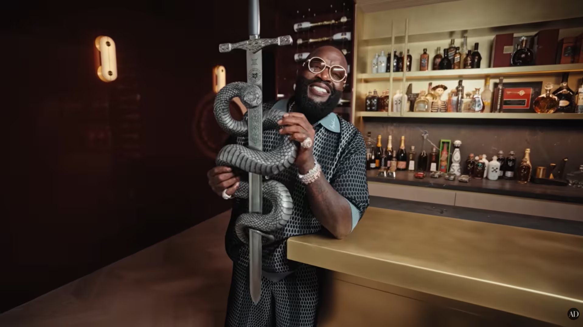 La espada se exhibe como una pieza decorativa de carácter simbólico, integrada al relato de poder y puesta en escena que Rick Ross construye en su mansión, entre objetos curados y guiños a su estética personal. (Video Youtube /Architectural Digest)