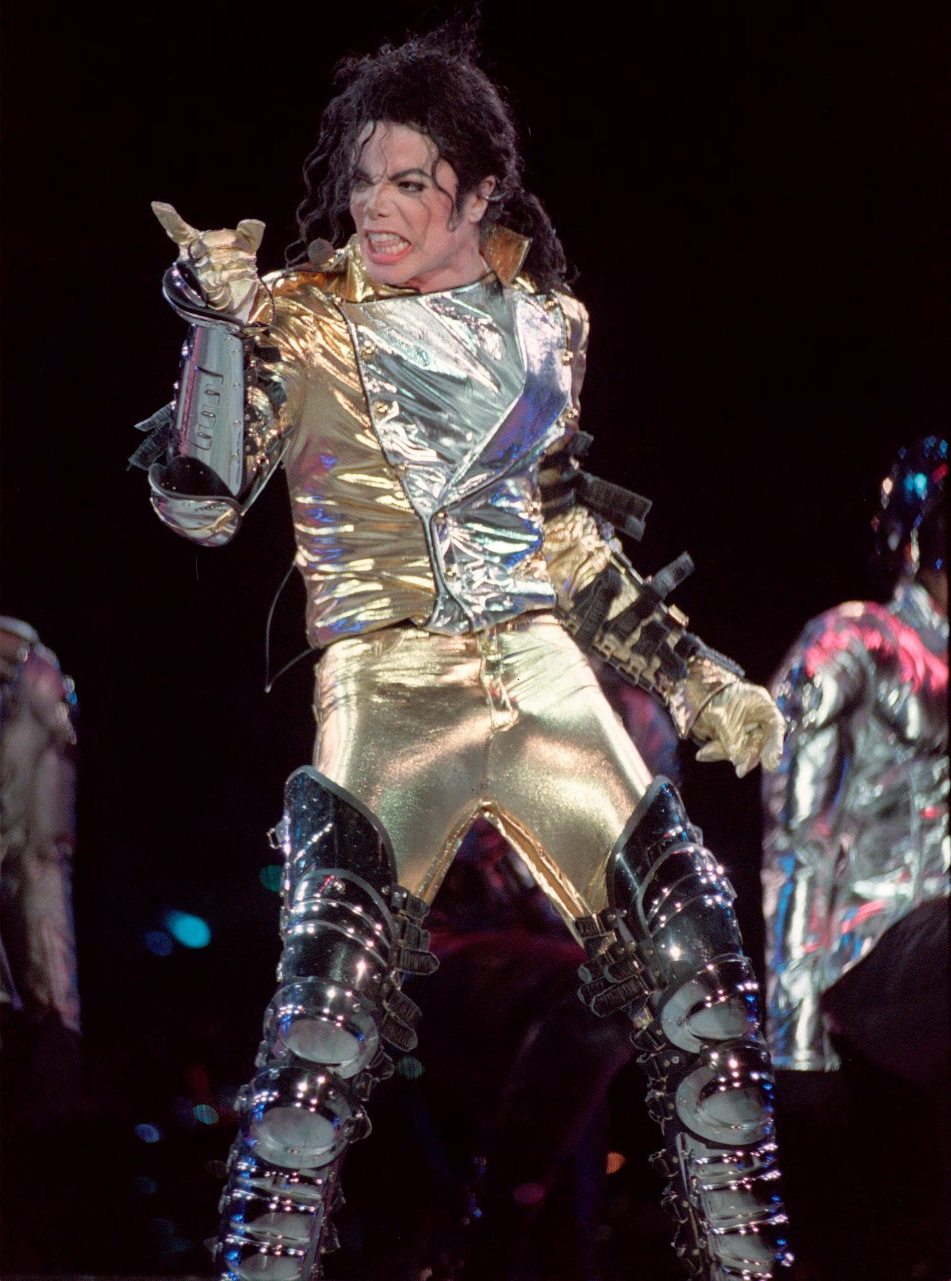 Esta imagen muestra a Michael Jackson con un icónico traje dorado diseñado por Gianni Versace durante su gira HIStory World Tour en 1996 ( EFE/Javier Cebollada/Archivo) 