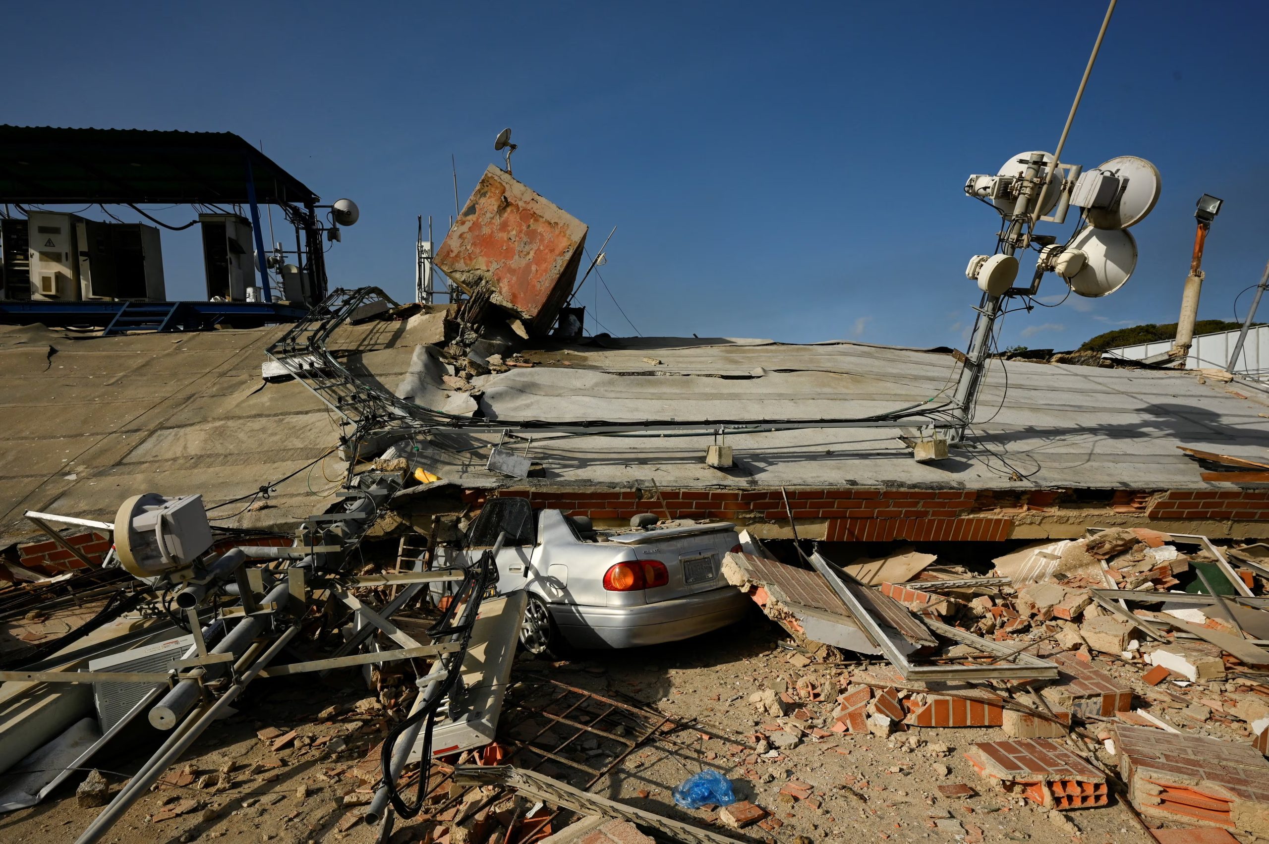 Un vehículo permanece aplastado bajo los restos de un edificio colapsado tras los terremotos (REUTERS)