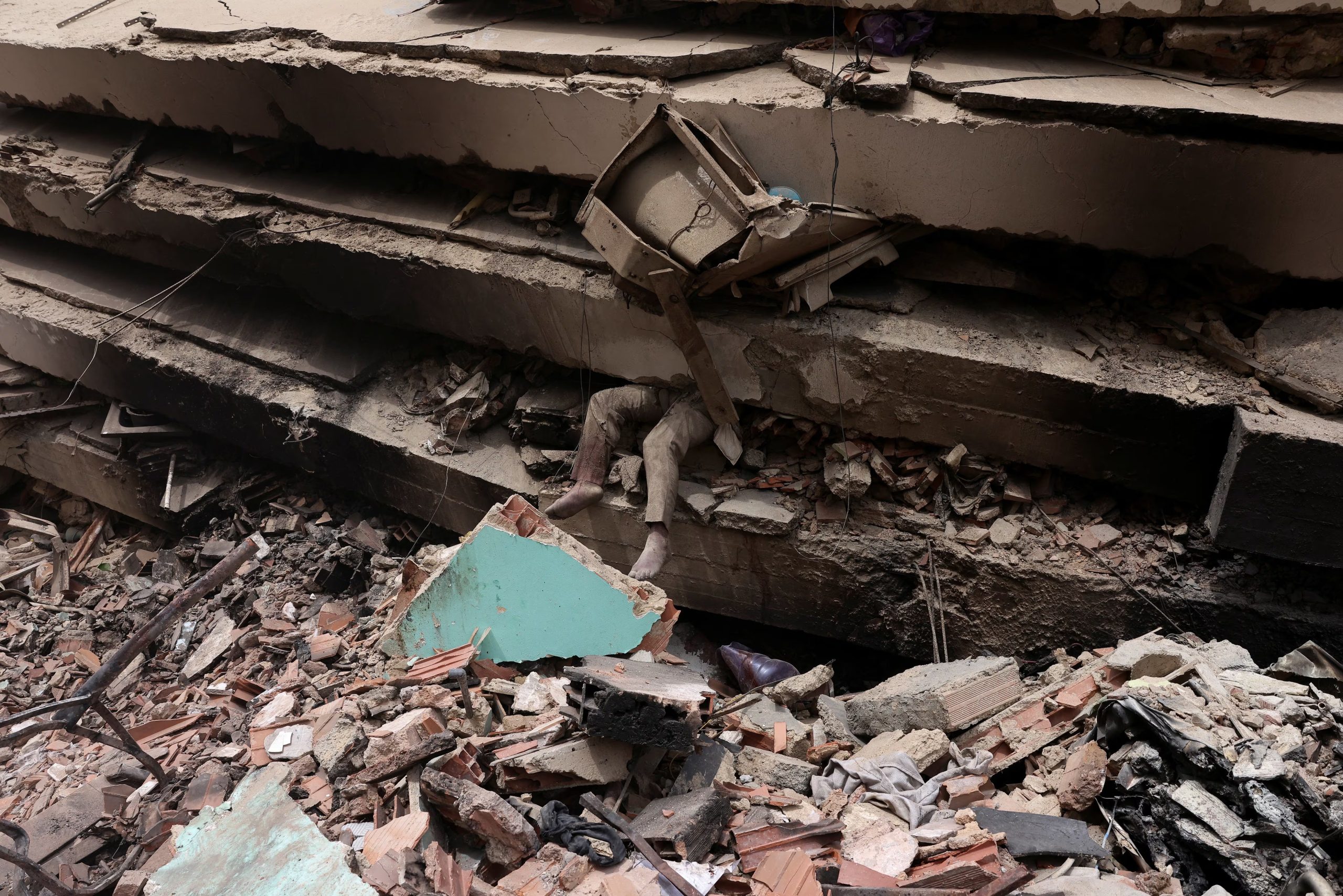 Tras los sismos, una víctima es visible entre los restos de un inmueble colapsado en La Guaira, Venezuela (REUTERS)