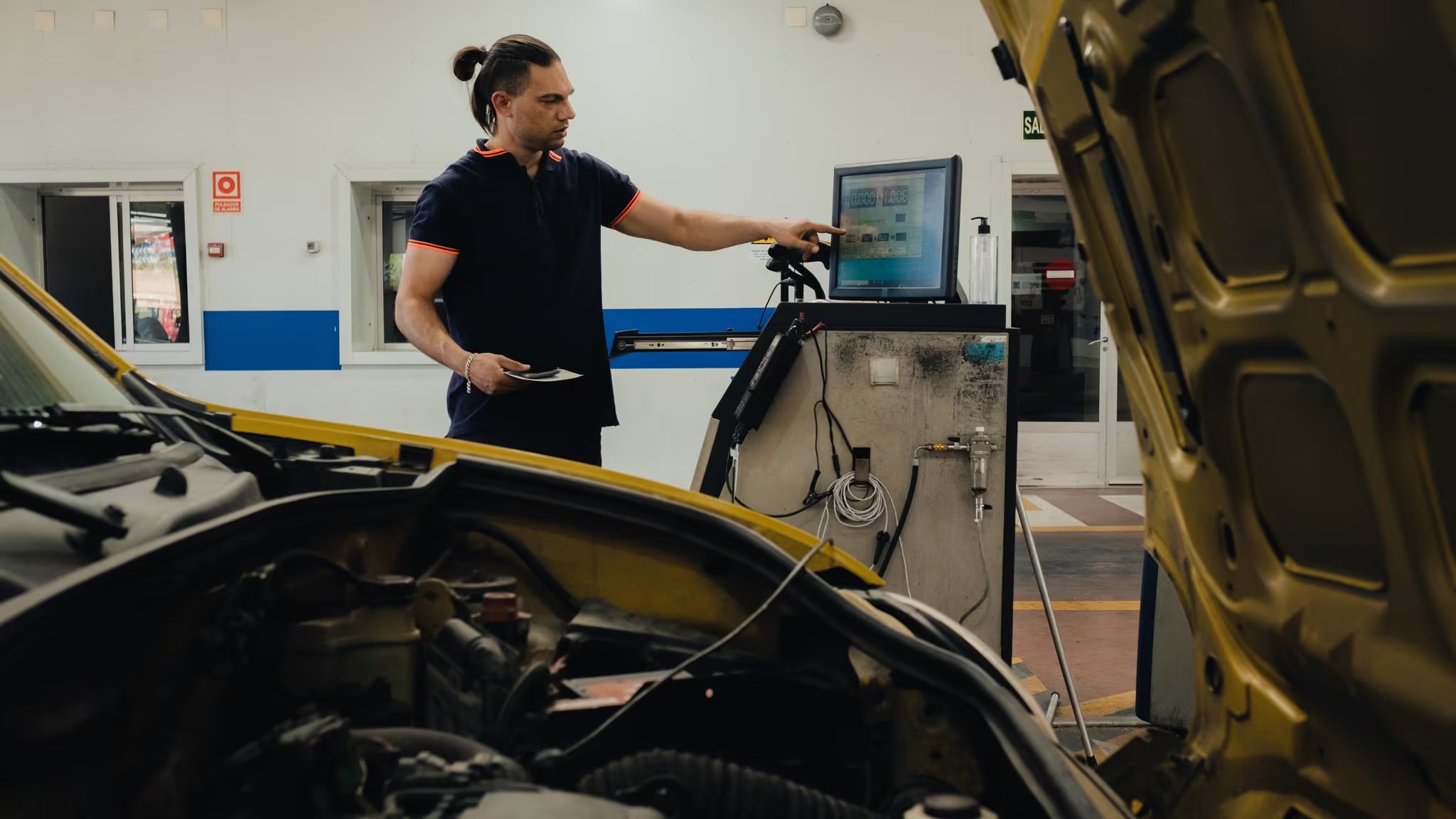 Mecánico realizando una inspección a un coche (AECA-ITV)