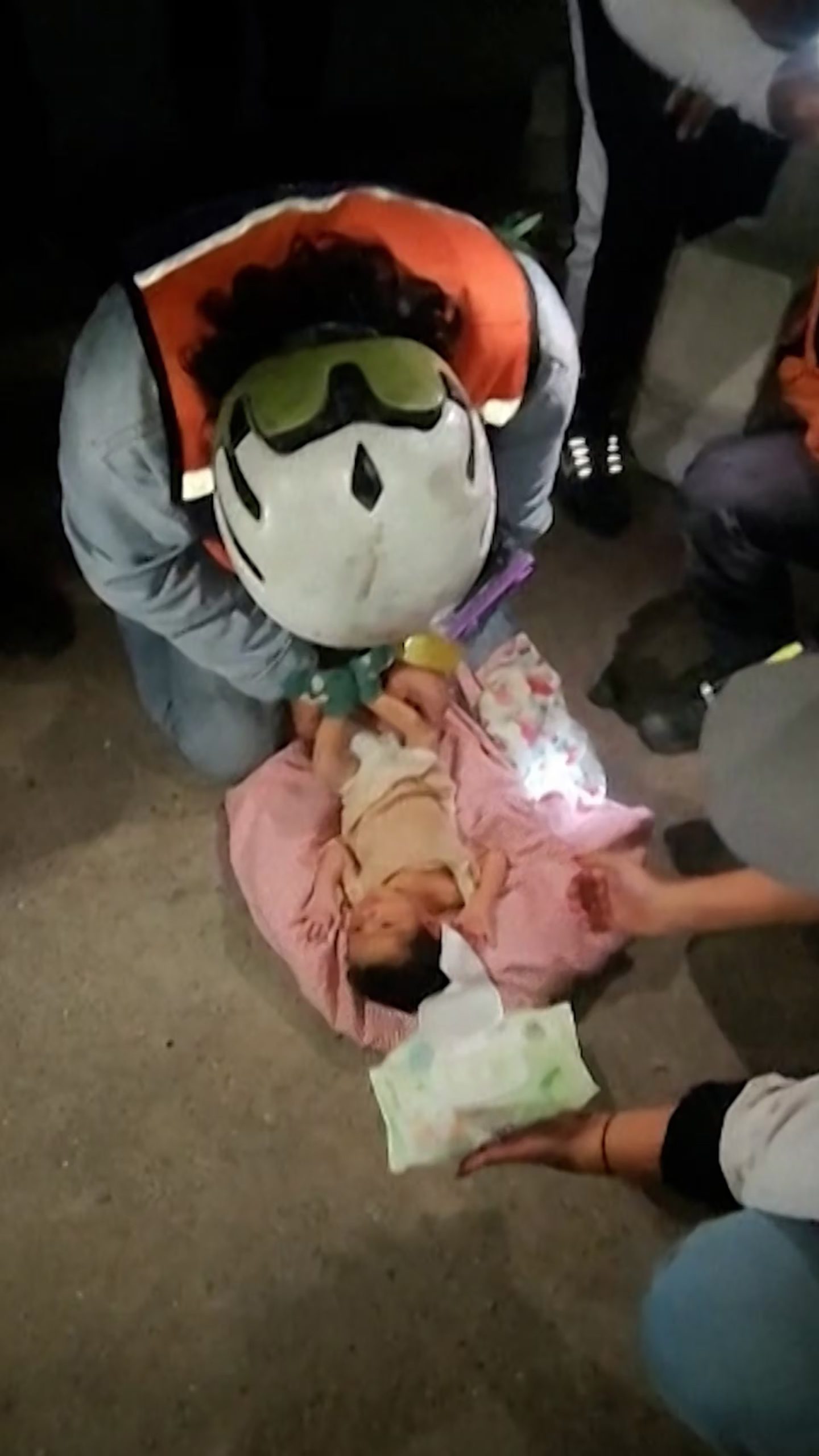 Un rescatista apoya al bebé en el suelo (Capturas de video)