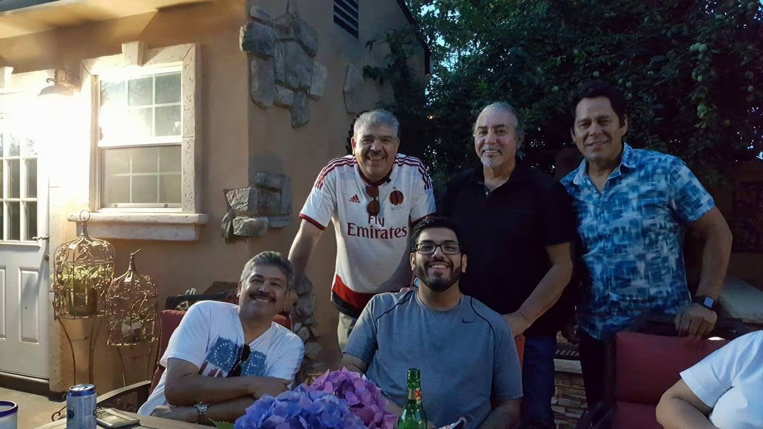 La imagen muestra a Eddie Valdivia reunido con un grupo de hombres en un ambiente exterior, posiblemente un jardín o patio, durante una jornada social. (Facebook)