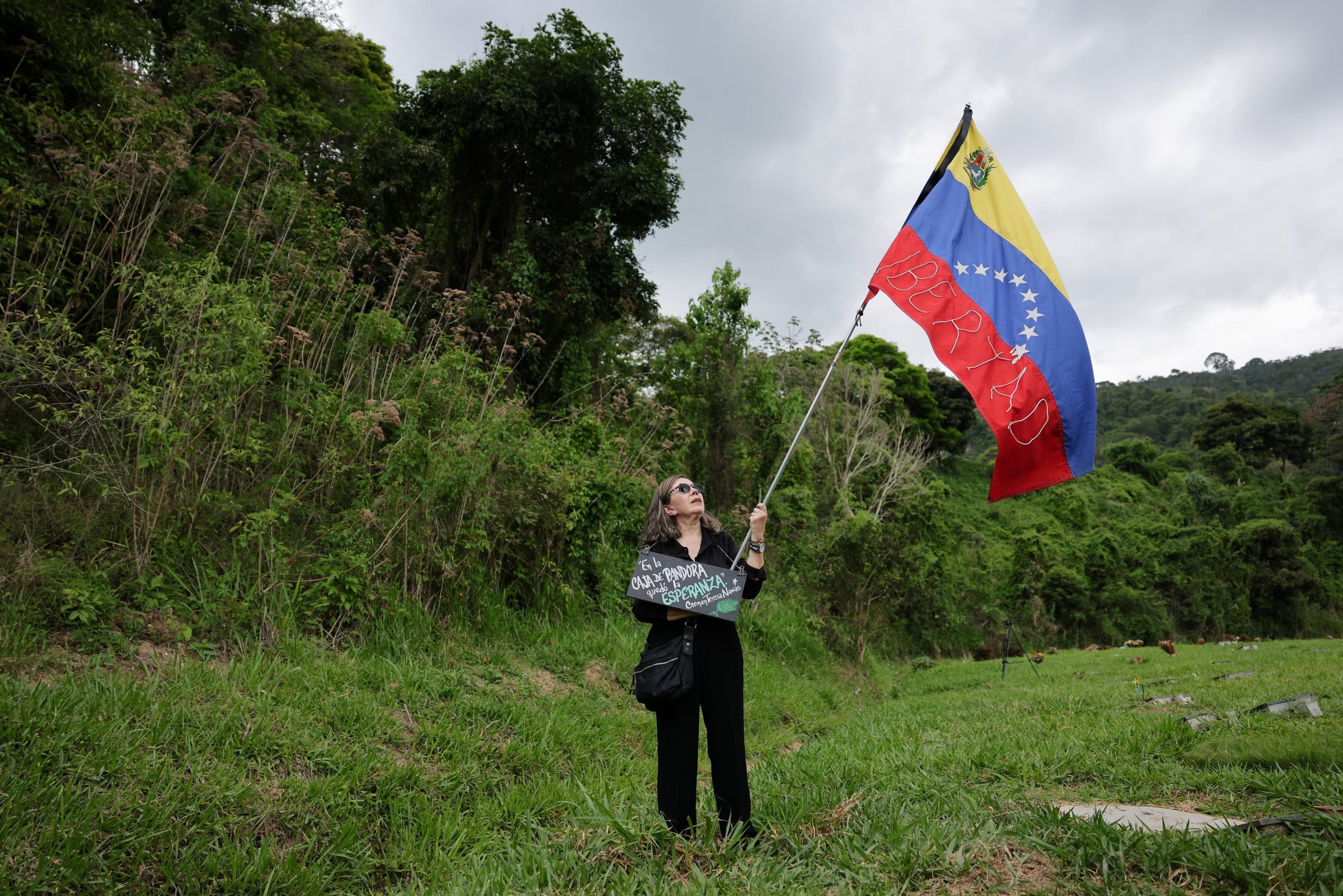 Una mujer ondea una bandera venezolana durante el funeral de Carmen Navas, una madre de 82 años que pasó casi un año buscando a su hijo detenido, Víctor Quero (REUTERS/Gaby Oraa)
