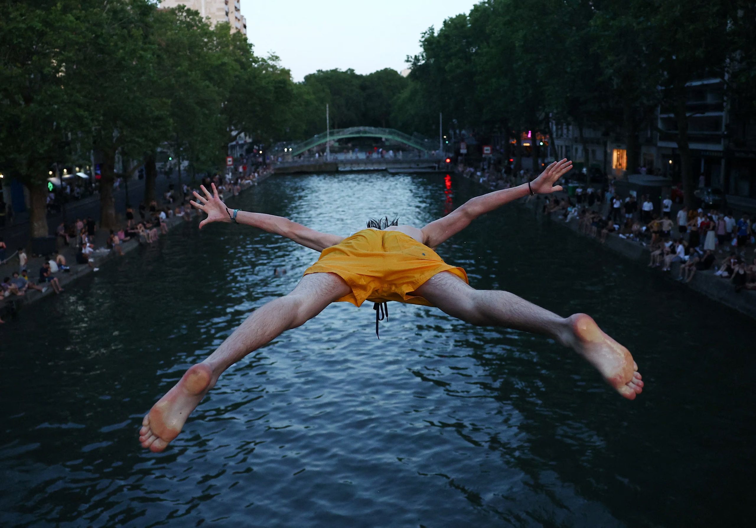 Un hombre se lanza al agua en el Canal Saint-Martin de París, el 22 de junio de 2026, en medio de la ola de calor que golpea a Francia. (Foto Reuters/Abdul Saboor)