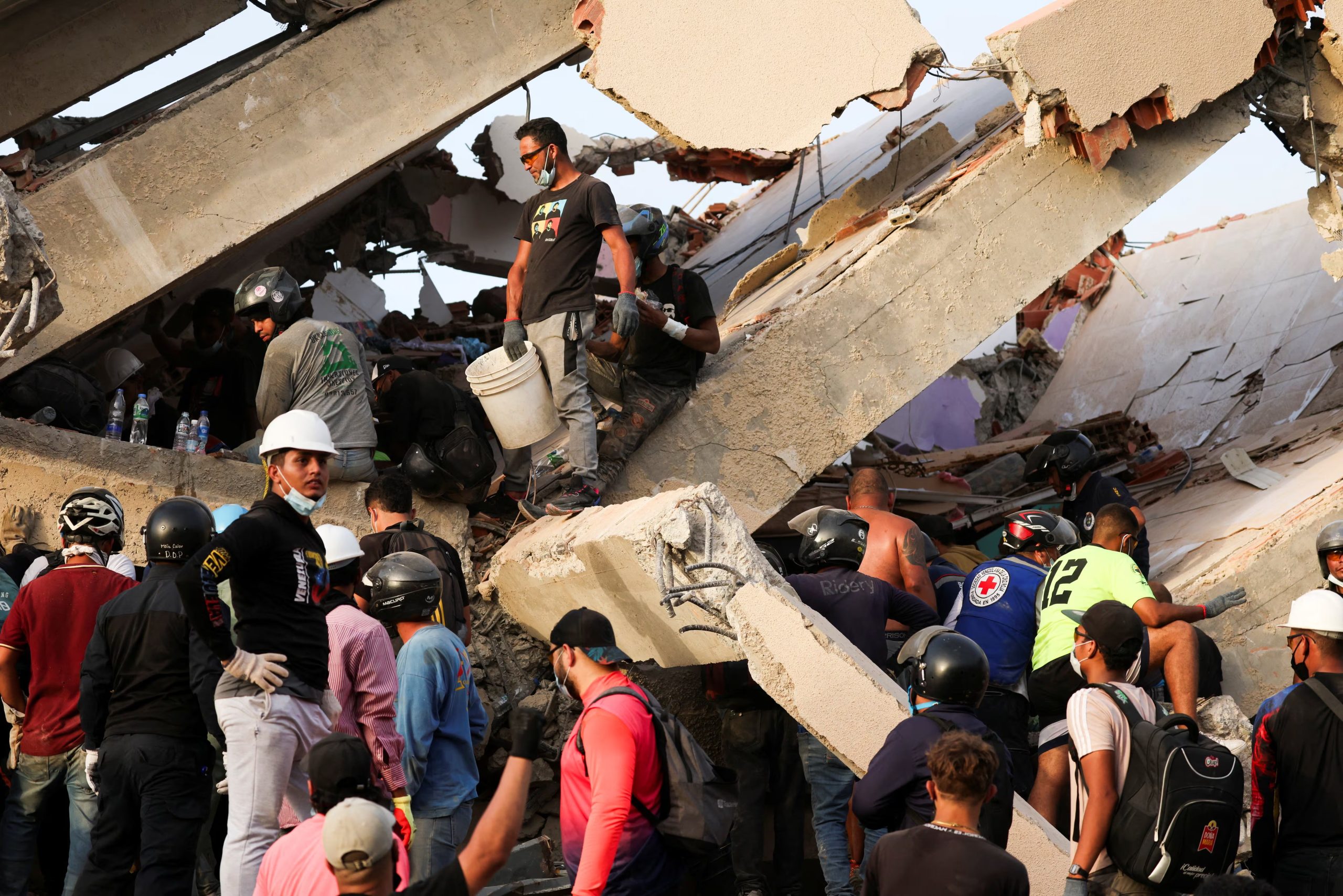 Personas buscan sobrevivientes entre los escombros de un edificio derrumbado tras un terremoto en La Guaira, Venezuela, el 26 de junio de 2026. REUTERS/Leonardo Fernández Viloria