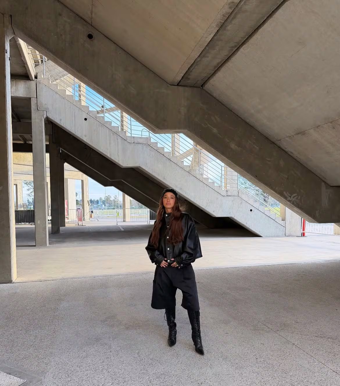 Ángela apostó por un look con botas altas, unas bermudas y una campera de cuerina, todo en color negro