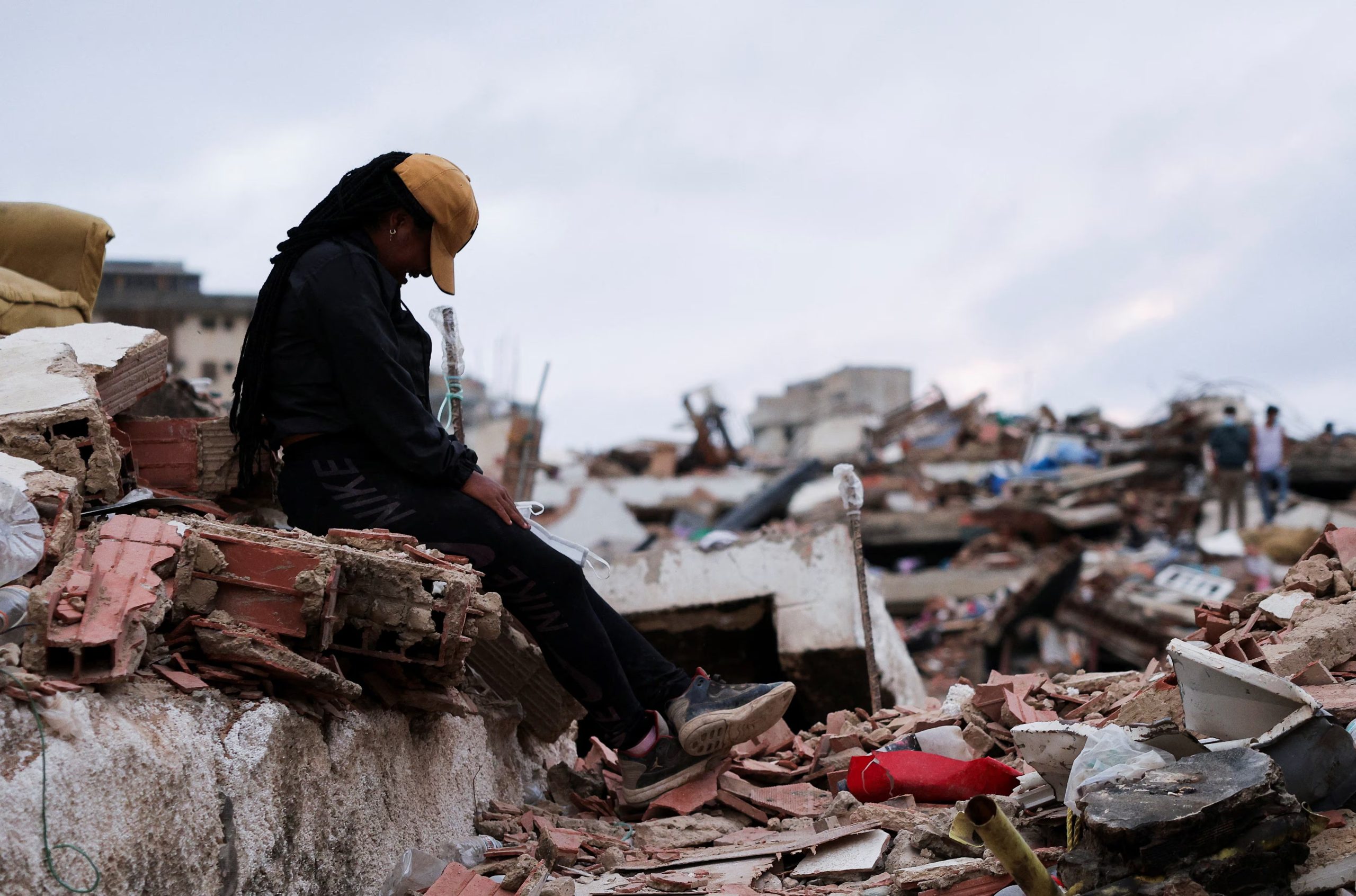 Hilyerin Subero encuentra las llaves de su esposo, Jeison Nieto, mientras busca entre los escombros tras los mortales terremotos del 24 de junio (REUTERS)