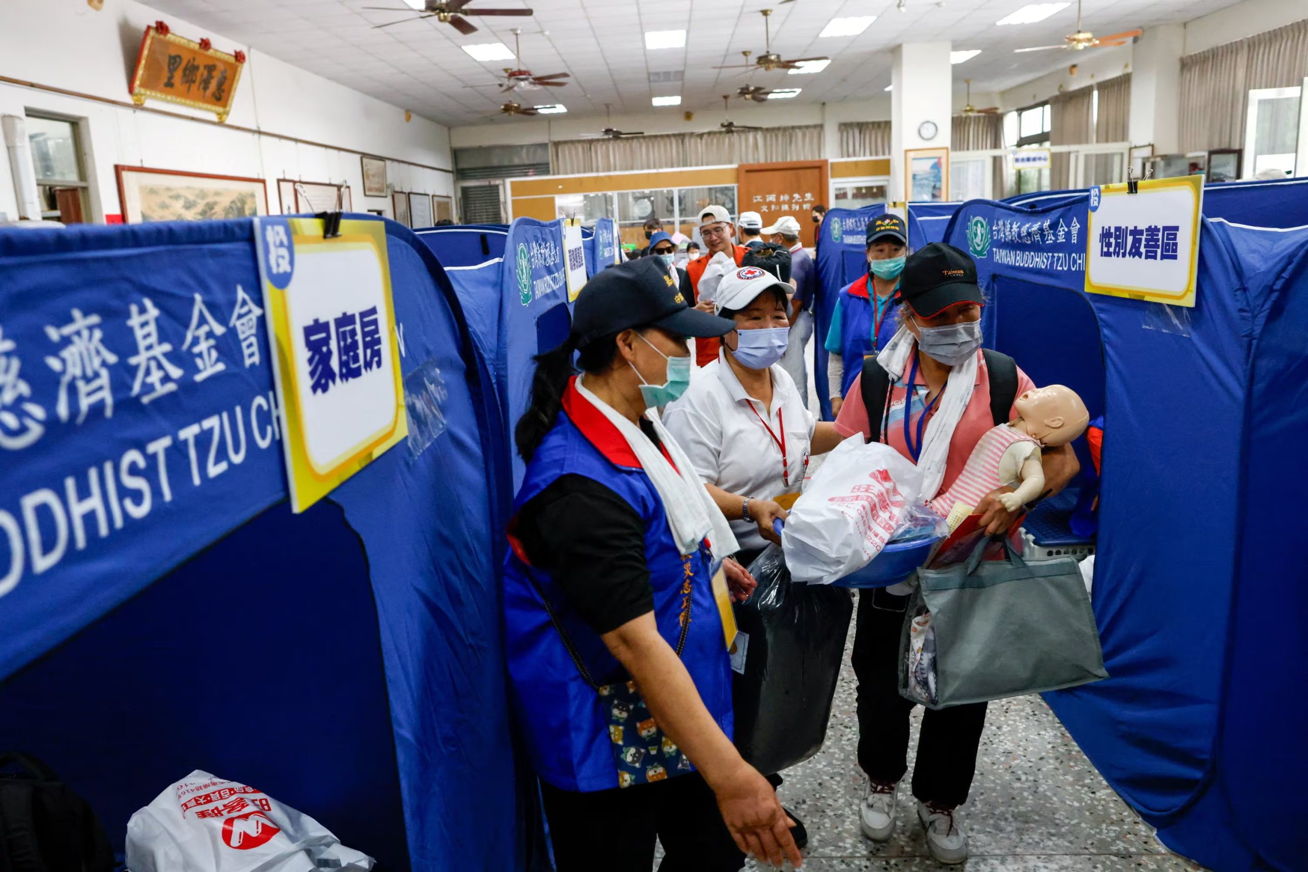 Los vecinos recogen provisiones y se instalan en un refugio temporal en un centro comunitario durante un simulacro de resiliencia en Nantou (REUTERS/Ann Wang)