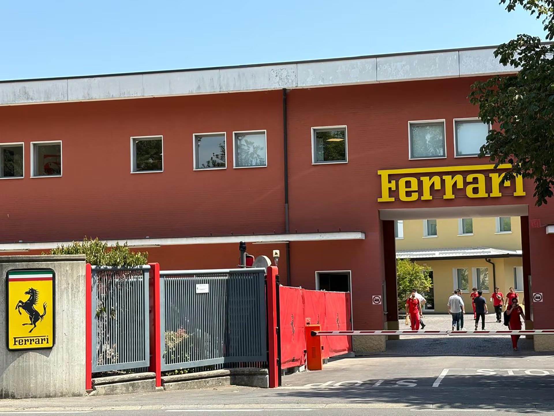 Fachada con el histórico portal de la Fábrica de Maranello. Mediodía con el egreso de los empleados y operarios.