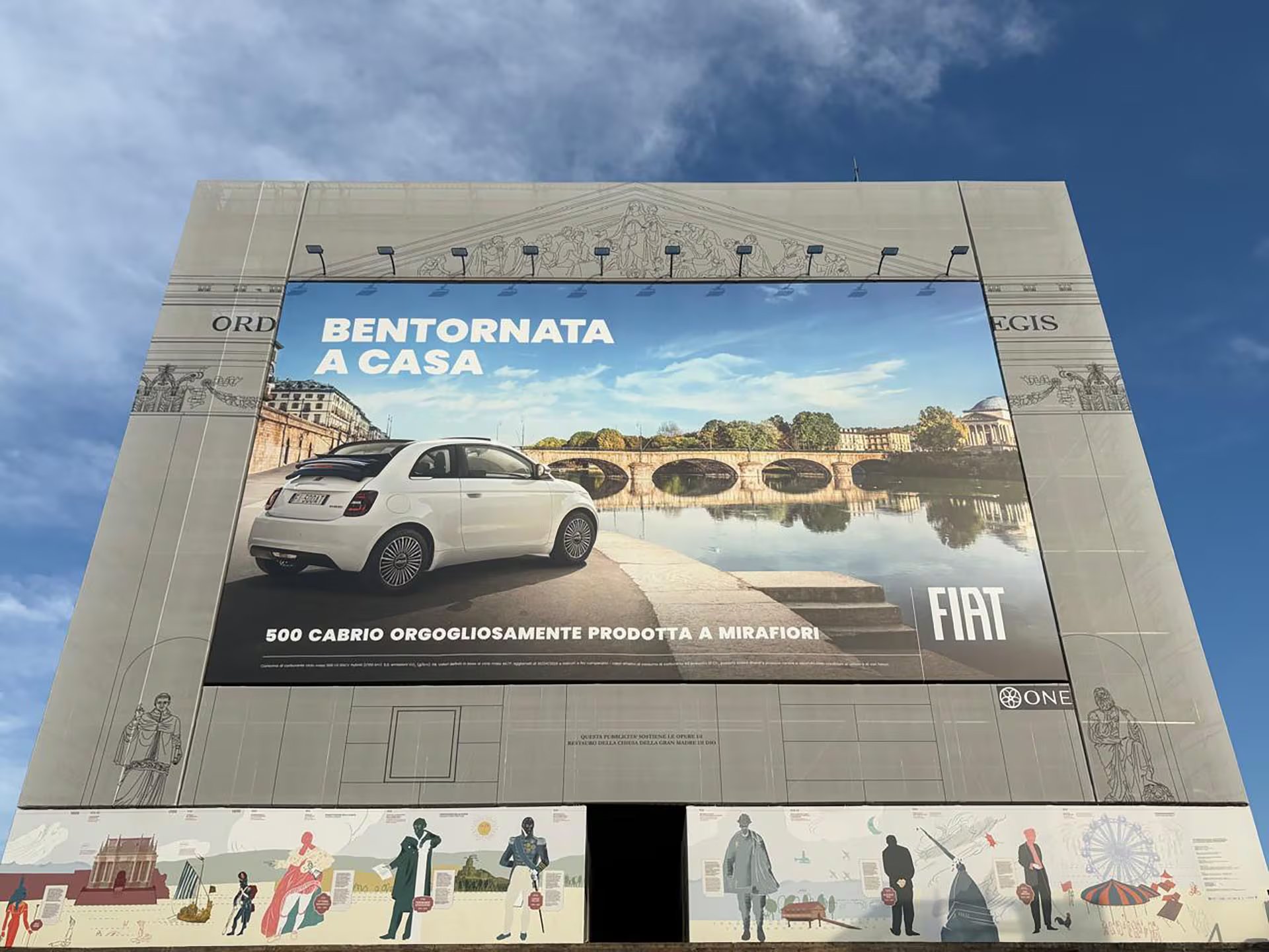 Bienvenida nuevamente a Casa. Fiat 500 Cabrio. Orgullosamente producida en Mirafiori. Gigantografía sobre la fachadas de la Iglesia de la Gran Madre de Dios, en el corazón de Turín.