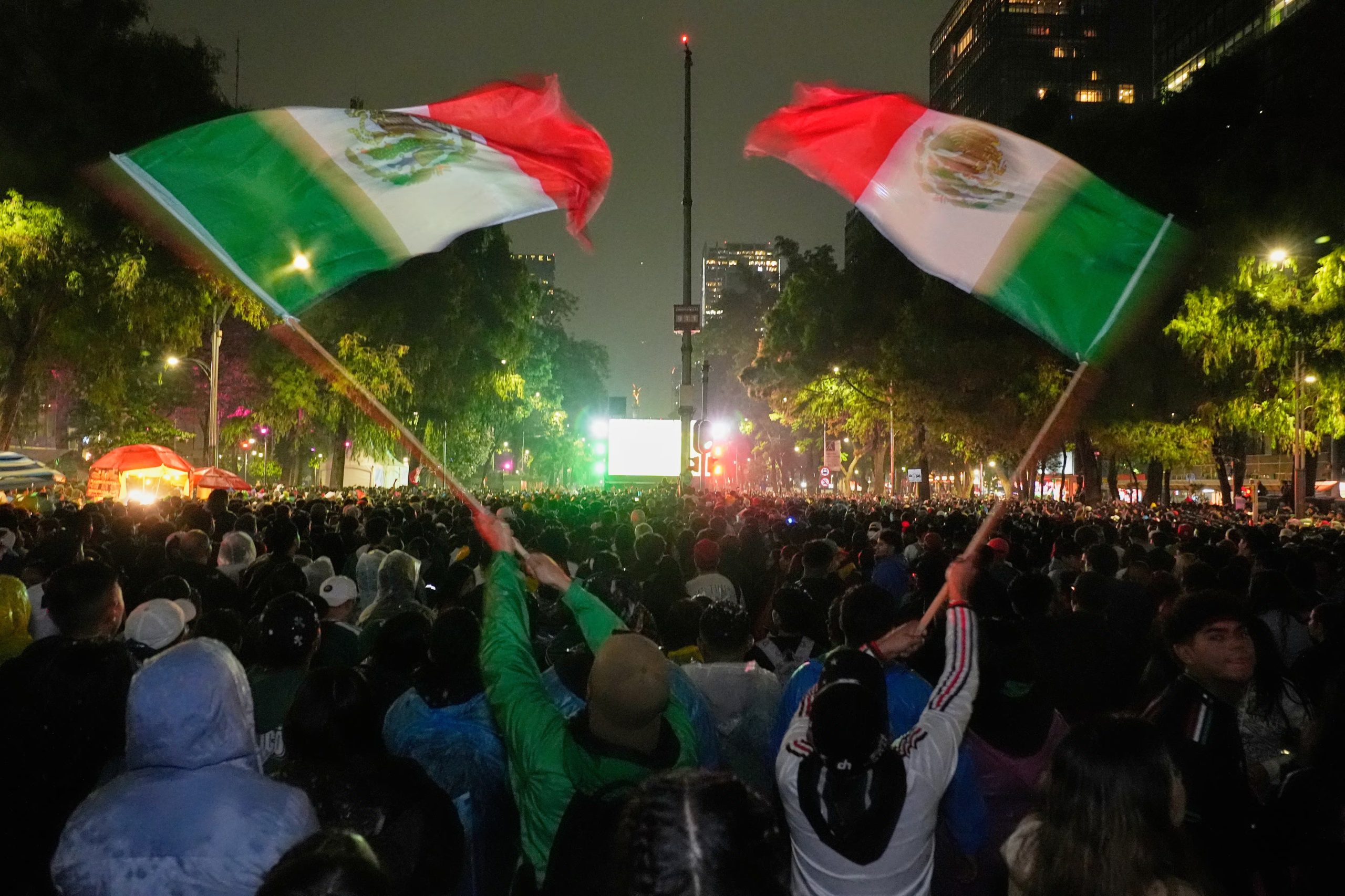 Aficionados mexicanos ondean banderas mientras observan el partido de dieciseisavos de final del Mundial entre México y Ecuador cerca del monumento al Ángel de la Independencia en la Ciudad de México, el martes 30 de junio de 2026. (AP Foto/Marco Ugarte)