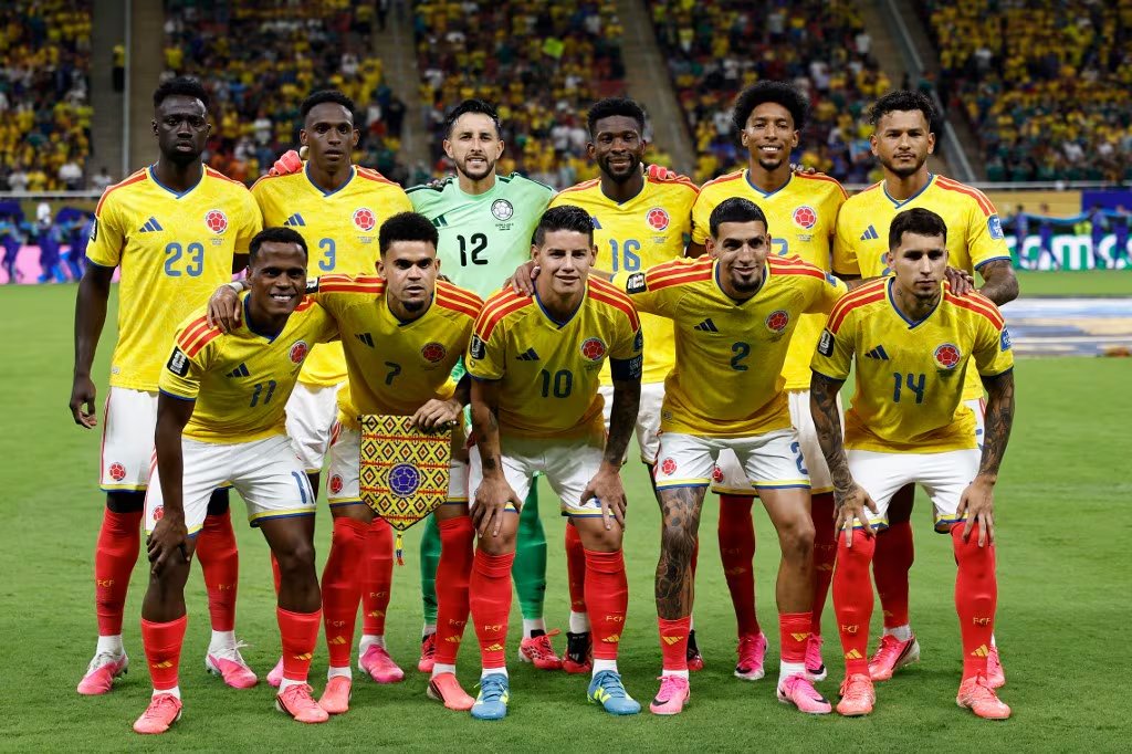 Once jugadores de la selección nacional de fútbol de Colombia posan uniformados con su camiseta amarilla en el césped de un estadio antes de un encuentro, con las tribunas de fondo - crédito Ulises Ruiz