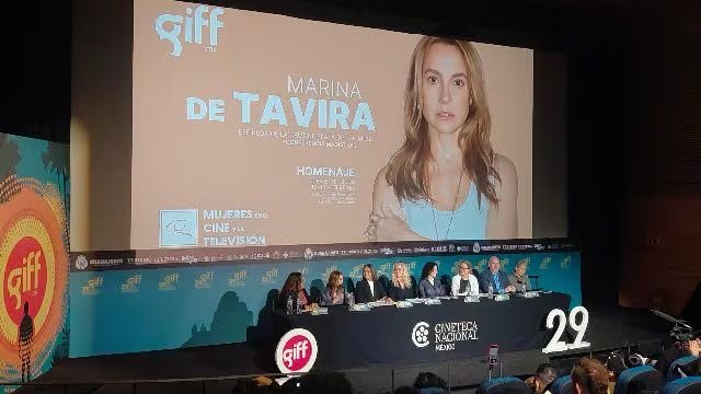Un panel de personas participa en un homenaje a Marina de Tavira proyectado en una pantalla durante el Festival Internacional de Cine de Guanajuato. (Presentación GIFF/Selene Miranda)