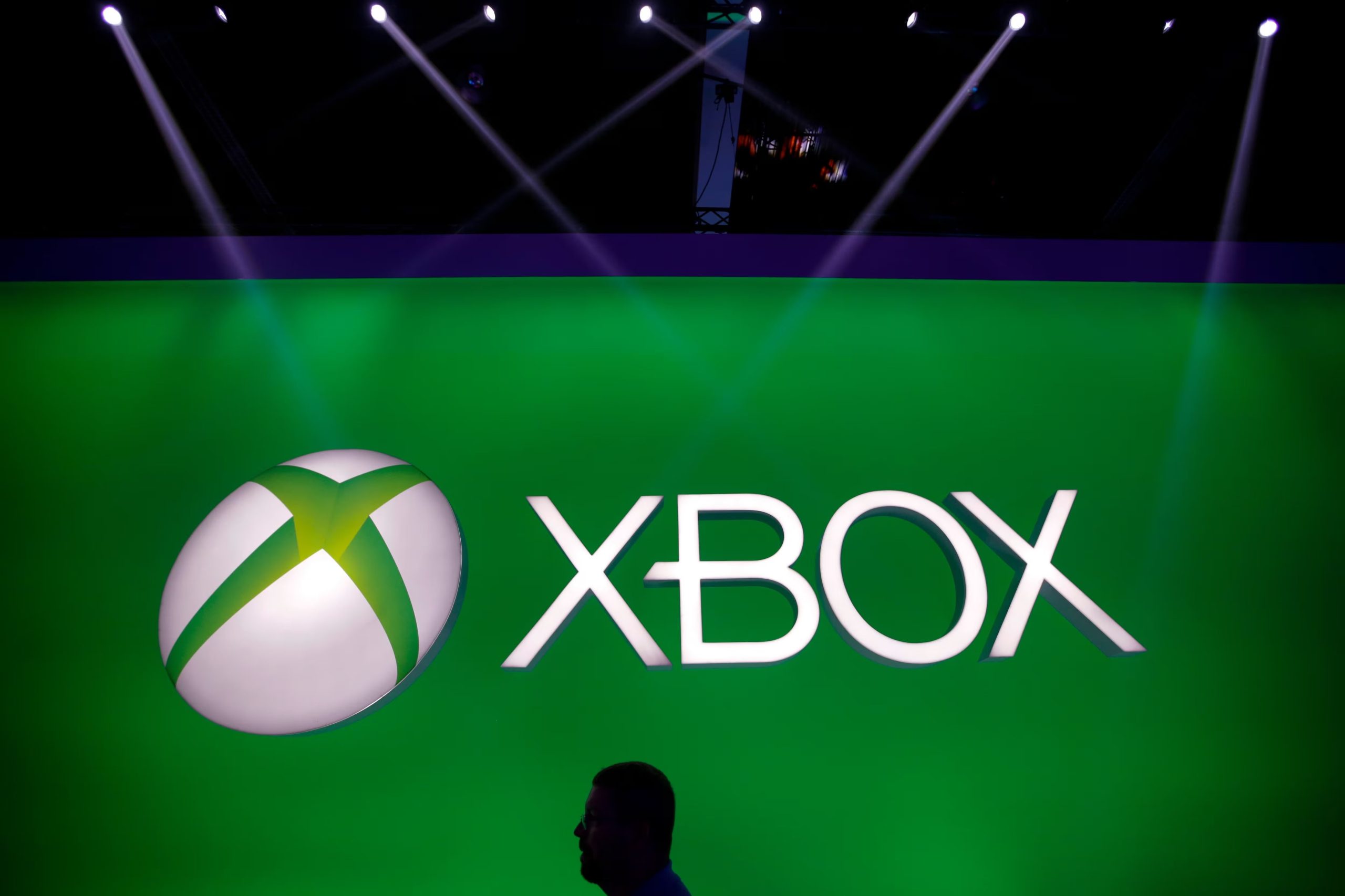 ARCHIVO - Un hombre pasa junto al logotipo de Xbox en el stand de Microsoft durante la feria de videojuegos E3 en Los Ángeles, el martes 11 de junio de 2013. (Foto AP/Jae C. Hong, archivo)