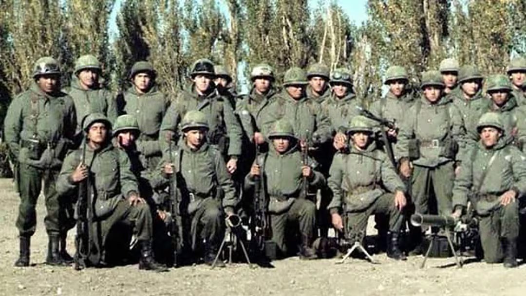 El entonces subteniente Villegas -el cuarto parado desde la izquierda, con antiparras en el casco- con su sección. Esta foto fue tomada el 1 de abril y solo él sabía que en horas volarían a las islas
