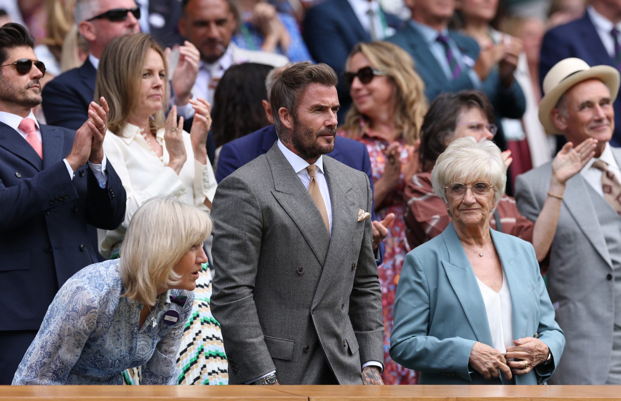 A David Beckham se lo vio con un traje cruzado gris claro con corbata beige, pañuelo a juego y reloj metálico