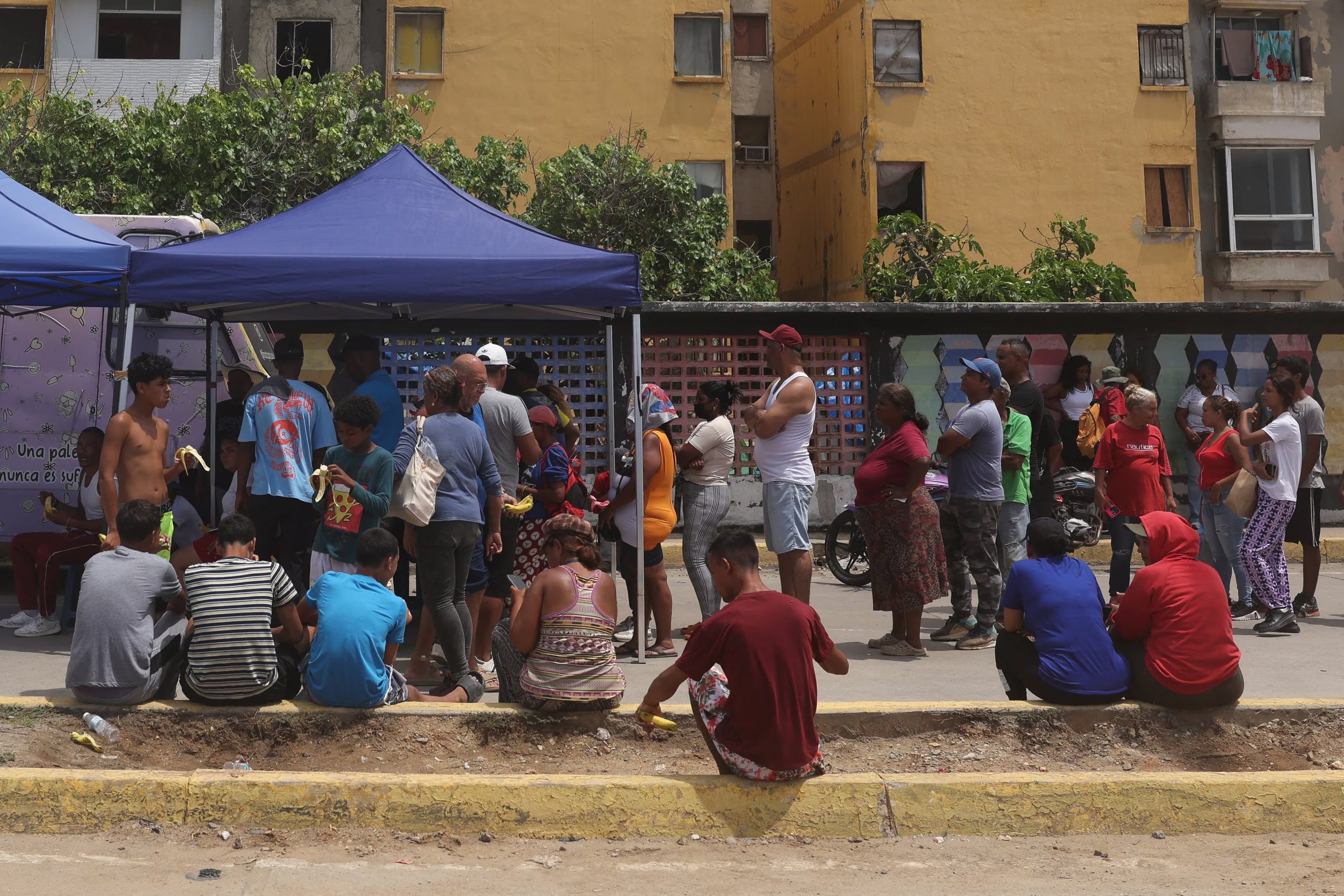 Personas hacen fila para recibir comida gratuita en un campamento improvisado frente a los edificios de la Misión Vivienda afectados por los terremotos del 24 de junio, en Catia La Mar, estado de La Guaira, Venezuela, 12 de julio de 2026. REUTERS/Leonardo Fernández Viloria