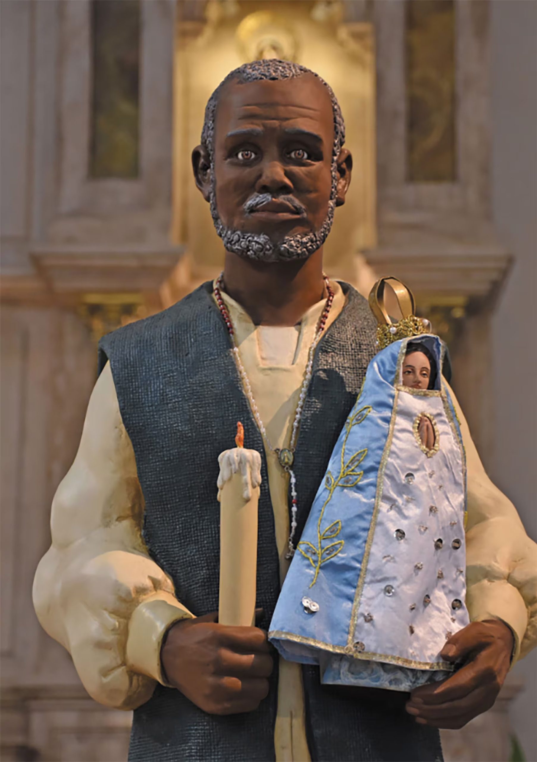 Una estatua del Negro Manuel sosteniendo la figura de la Virgen de Luján