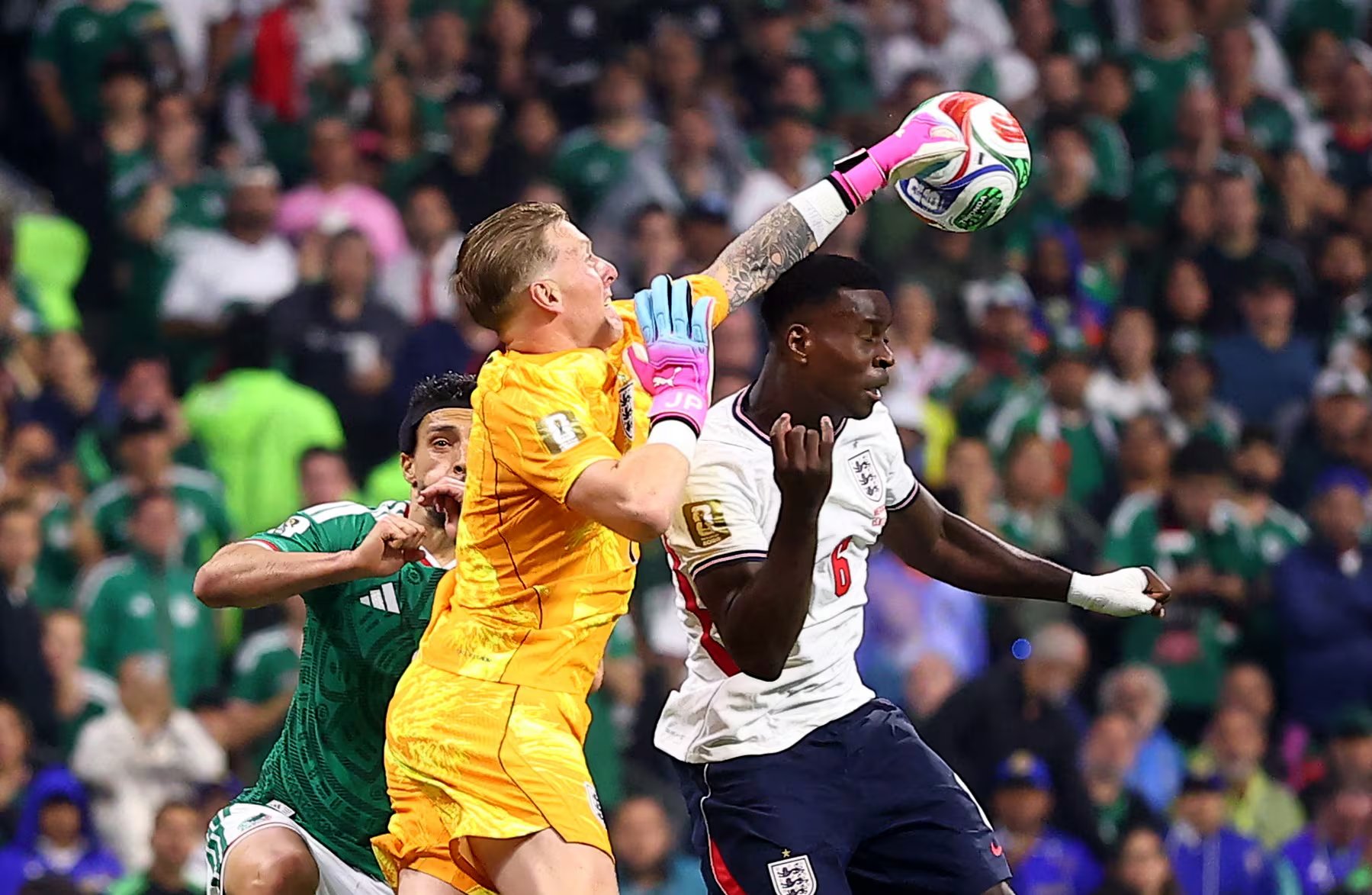 Soccer Football - FIFA World Cup 2026 - Round of 16 - Mexico v England - Estadio Azteca, Mexico City, Mexico - July 5, 2026 England's Jordan Pickford and Marc Guehi in action with Mexico's Raul Jimenez REUTERS/Eloisa Sanchez