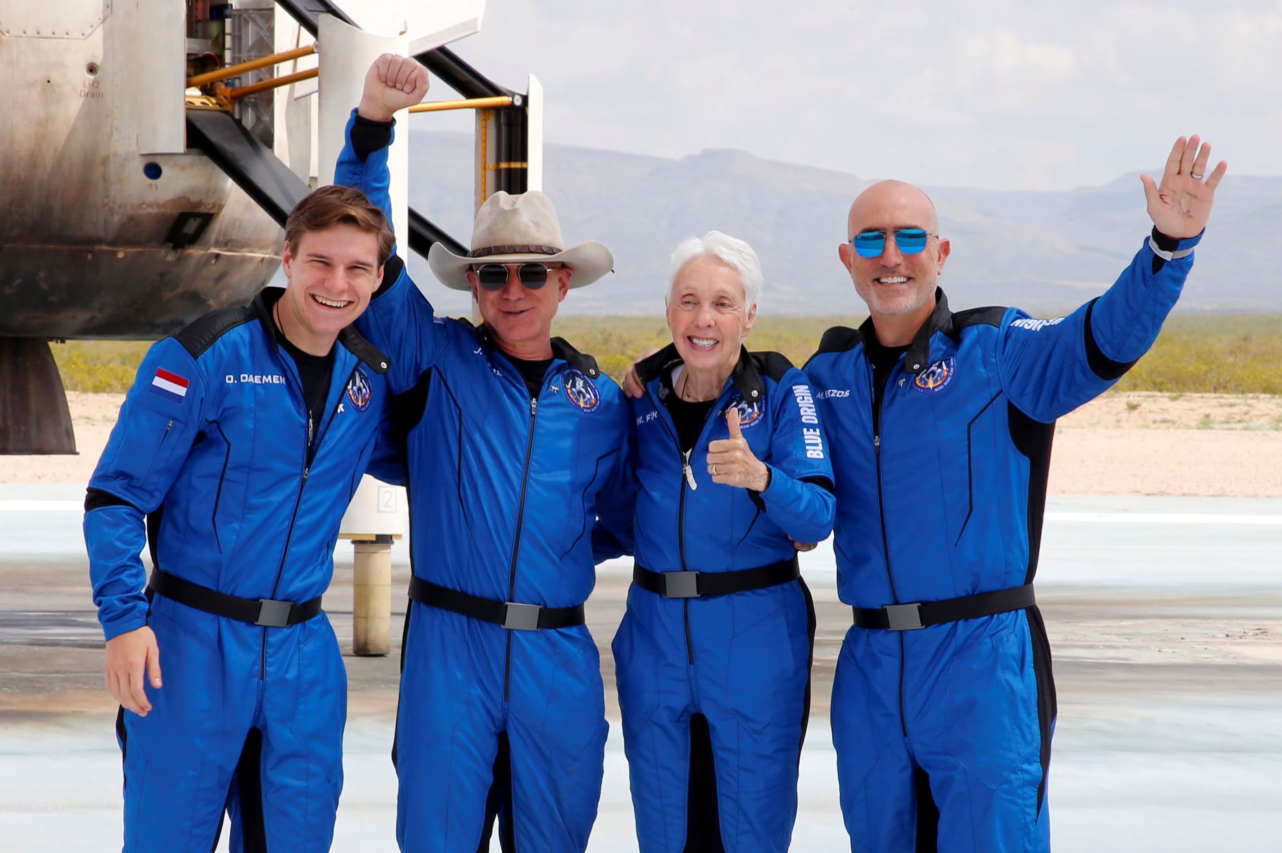 El multimillonario empresario estadounidense Jeff Bezos (segundo por la izquierda) posa para las fotos con sus compañeros de tripulación, de izquierda a derecha: Oliver Damen, de 18 años, Bezos, Wally Funk, de 82 años, y Mark Bezos, en la plataforma de aterrizaje tras el vuelo inaugural de Blue Origin al borde del espacio, en la cercana localidad de Van Horn, Texas, EE. UU., el 20 de julio de 2021 (REUTERS/Joe Skipper)
