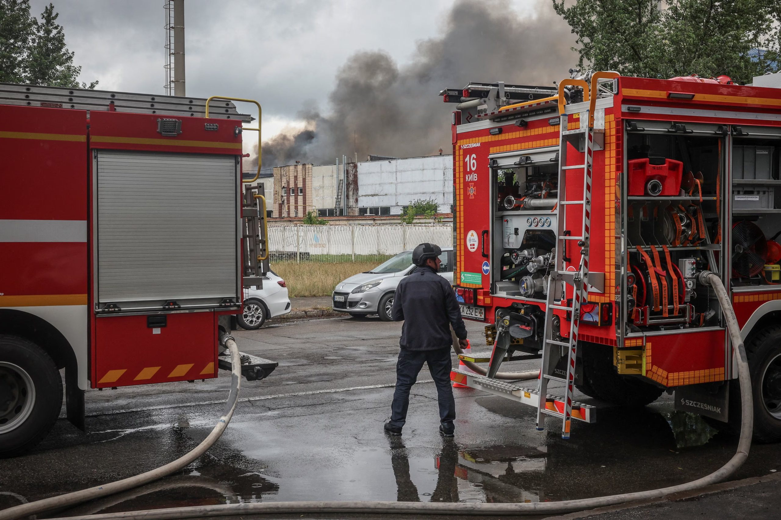 Un hombre se encuentra cerca de camiones de bomberos en el lugar de un ataque con drones rusos, mientras se eleva humo, en el marco de la ofensiva rusa contra Ucrania, en Kiev, el 8 de julio de 2026 (REUTERS/Alina Smutko)