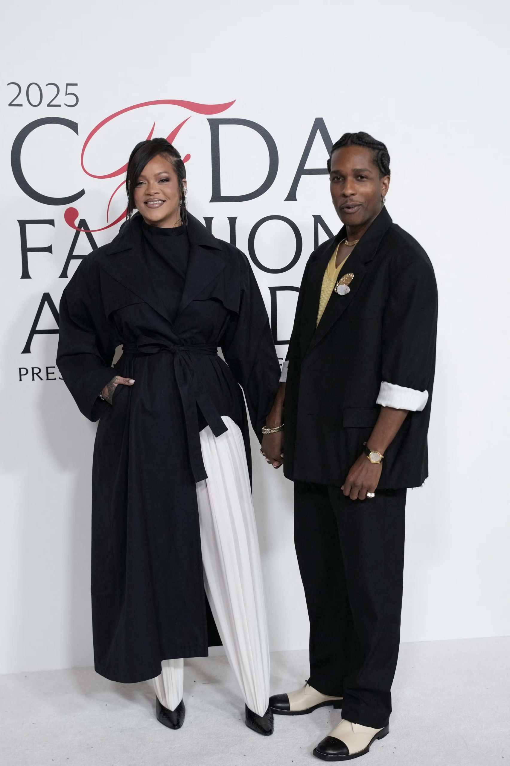 Rihanna redefine el blanco y negro con abrigo oversize y pantalón de pinzas, A$AP Rocky suma mostaza, botines bicolor y accesorios dorados (REUTERS/Eduardo Munoz)